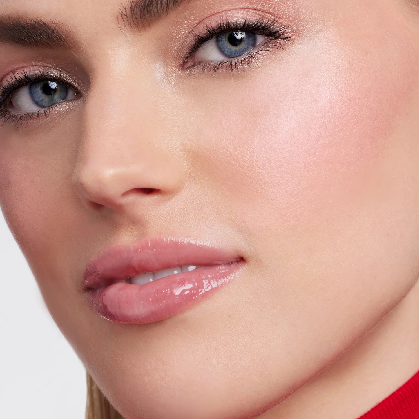 Close-up of a woman's face showcasing smooth skin and subtle makeup, featuring Glow Time® Blush Stick's natural, buildable finish on her cheeks.