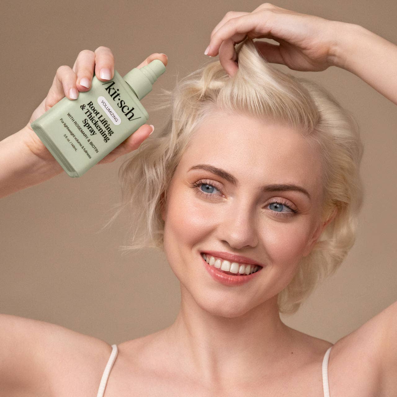 Woman holding Kitsch Volumizing Root Lifting & Thickening Spray, demonstrating its use for adding lightweight volume and fullness at hair roots.