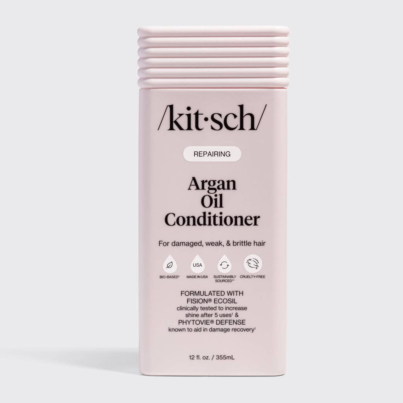 Pale-pink bottle of kitsch Repairing Argan Oil Conditioner for damaged hair, featuring sustainable, cruelty-free ingredients and enhancing shine and reducing frizz.