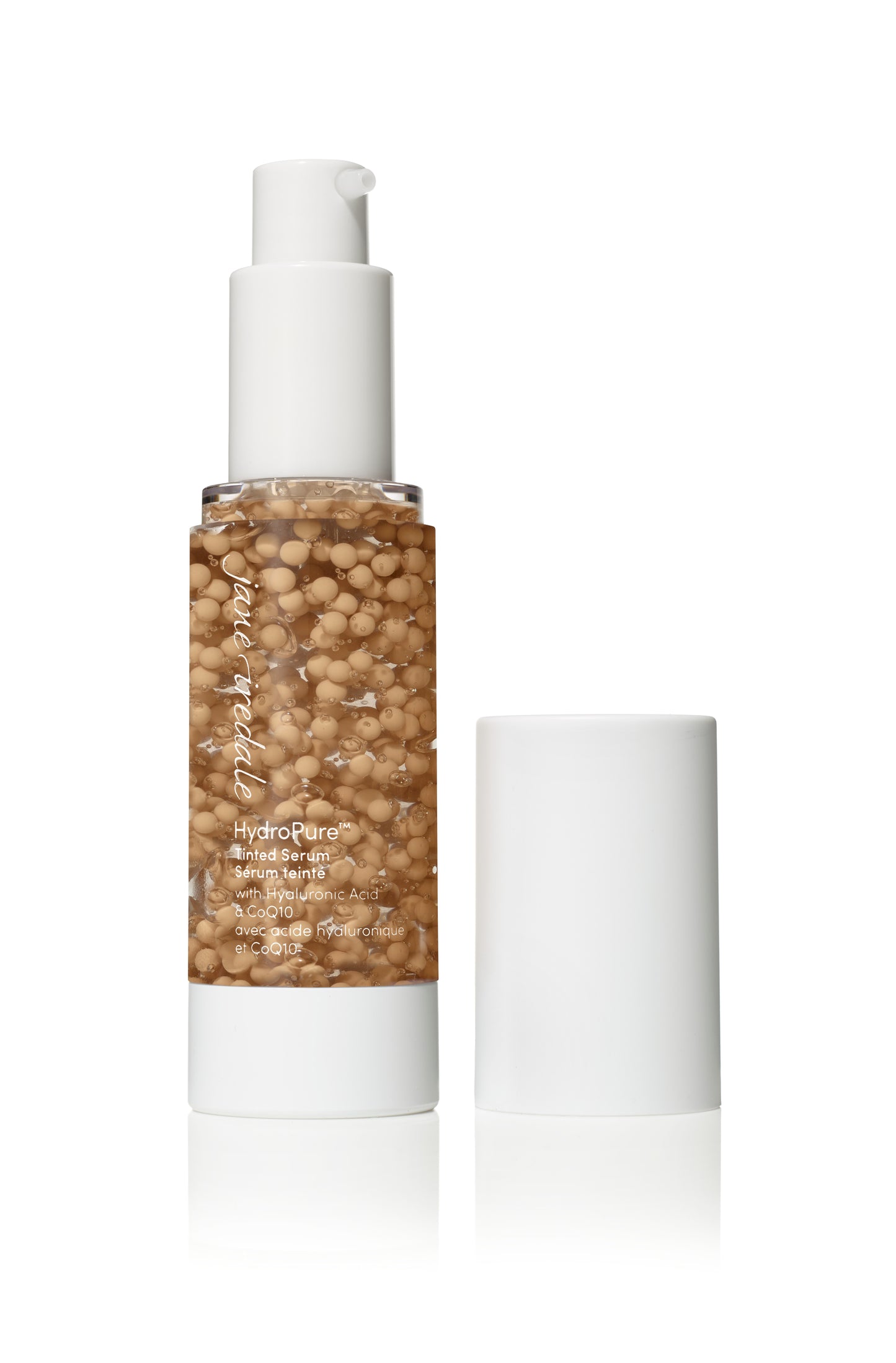 HydroPure™ Tinted Serum with Hyaluronic Acid and CoQ10 in a clear bottle, showing beige serum beads, cap beside, for luminous, hydrated skin.