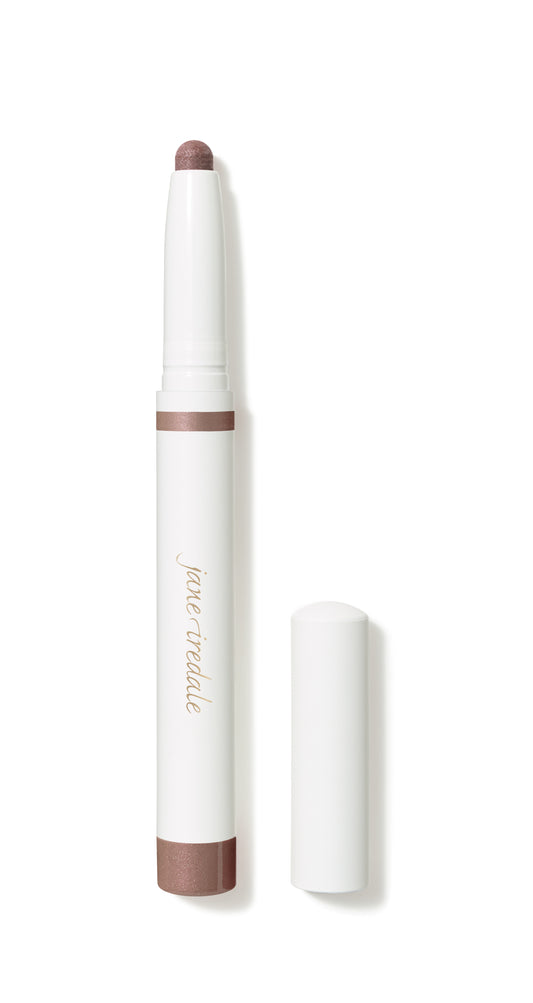 Jane Iredale ColorLuxe Eye Shadow Stick with shimmery rose-brown tip, white barrel, and gold lettering, offering blendable, long-wearing, crease-resistant color. Cap placed beside the stick.