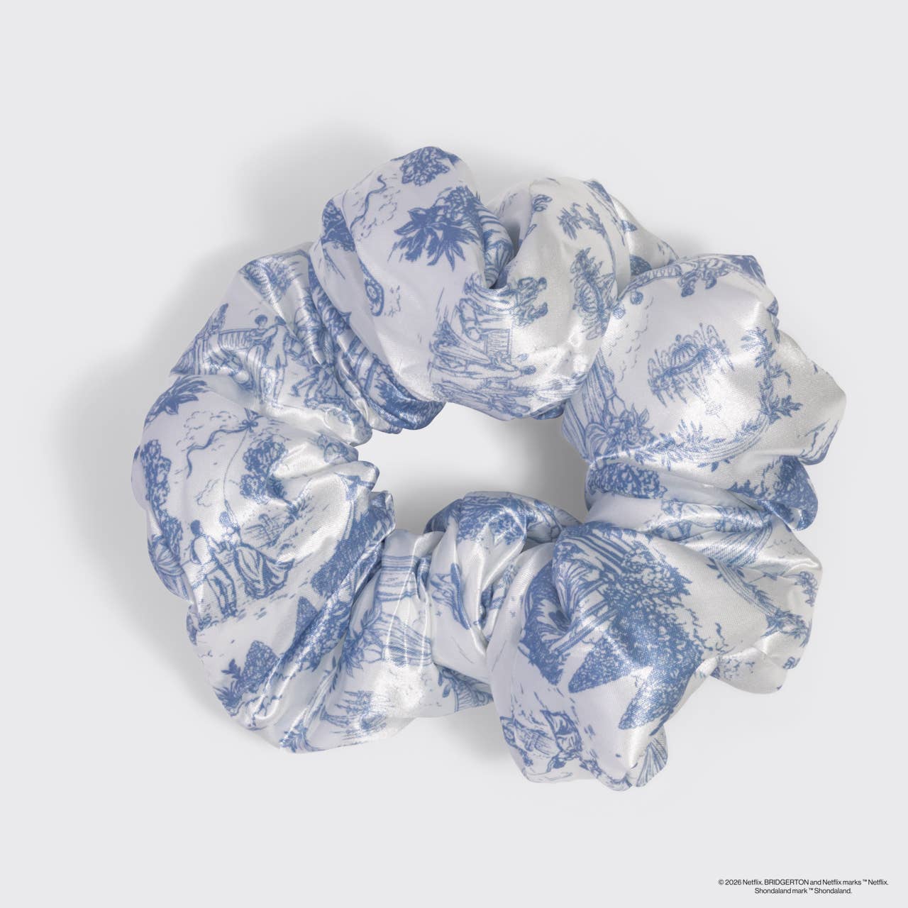 Bridgerton x Kitsch Satin Pillow Scrunchie® in Toile in Bloom, featuring blue pastoral prints on glossy white satin, offering gentle, snag-free hold for all hair types.