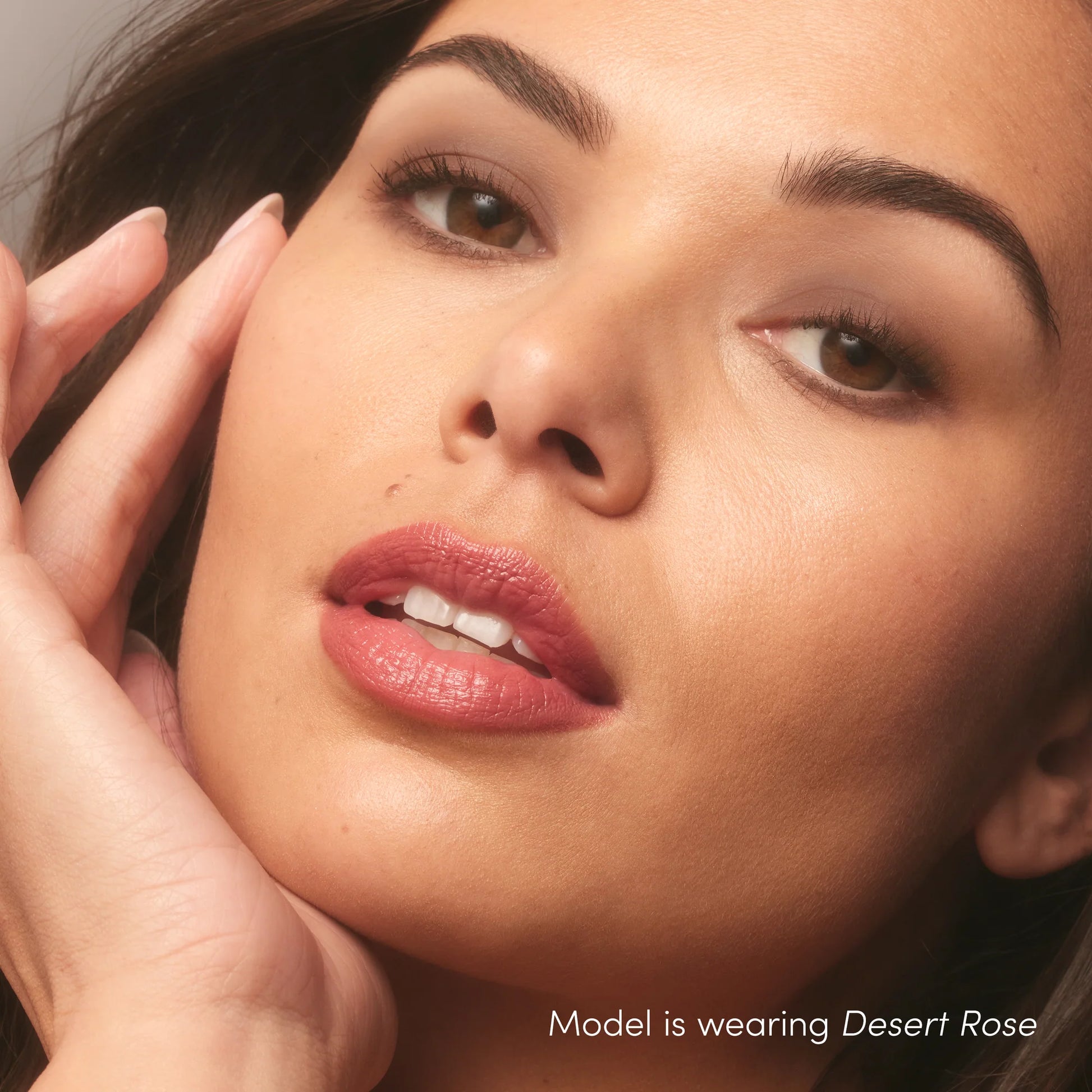 Close-up of a woman wearing ColorLuxe Hydrating Cream Lipstick in “Desert Rose,” showcasing smooth, radiant skin and a satin finish on her lips.