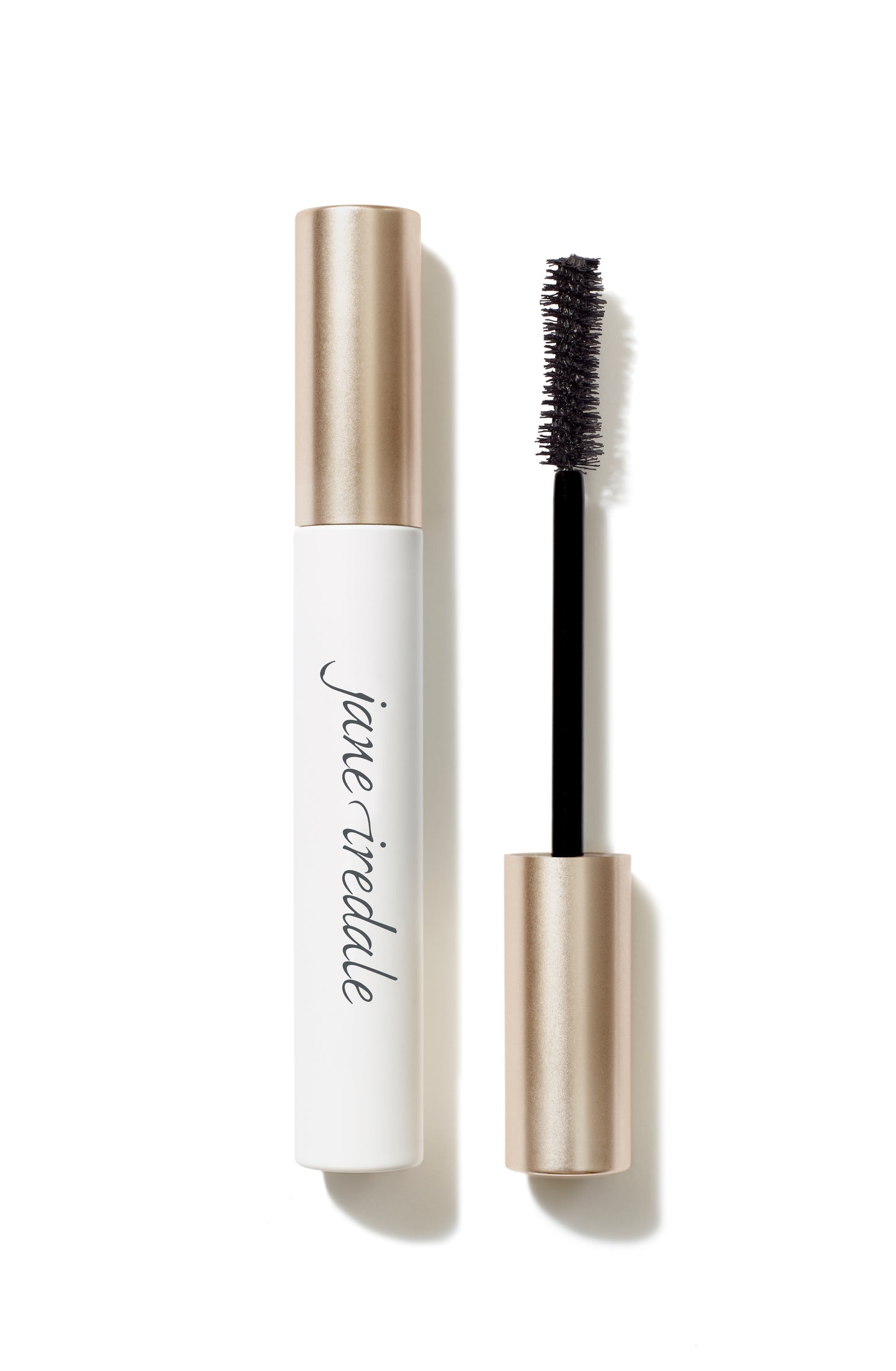 Beyond Lash™ Volumizing Mascara with a black bristle brush and white-and-rose-gold tube, offering buildable, naturally derived, nourishing volume.