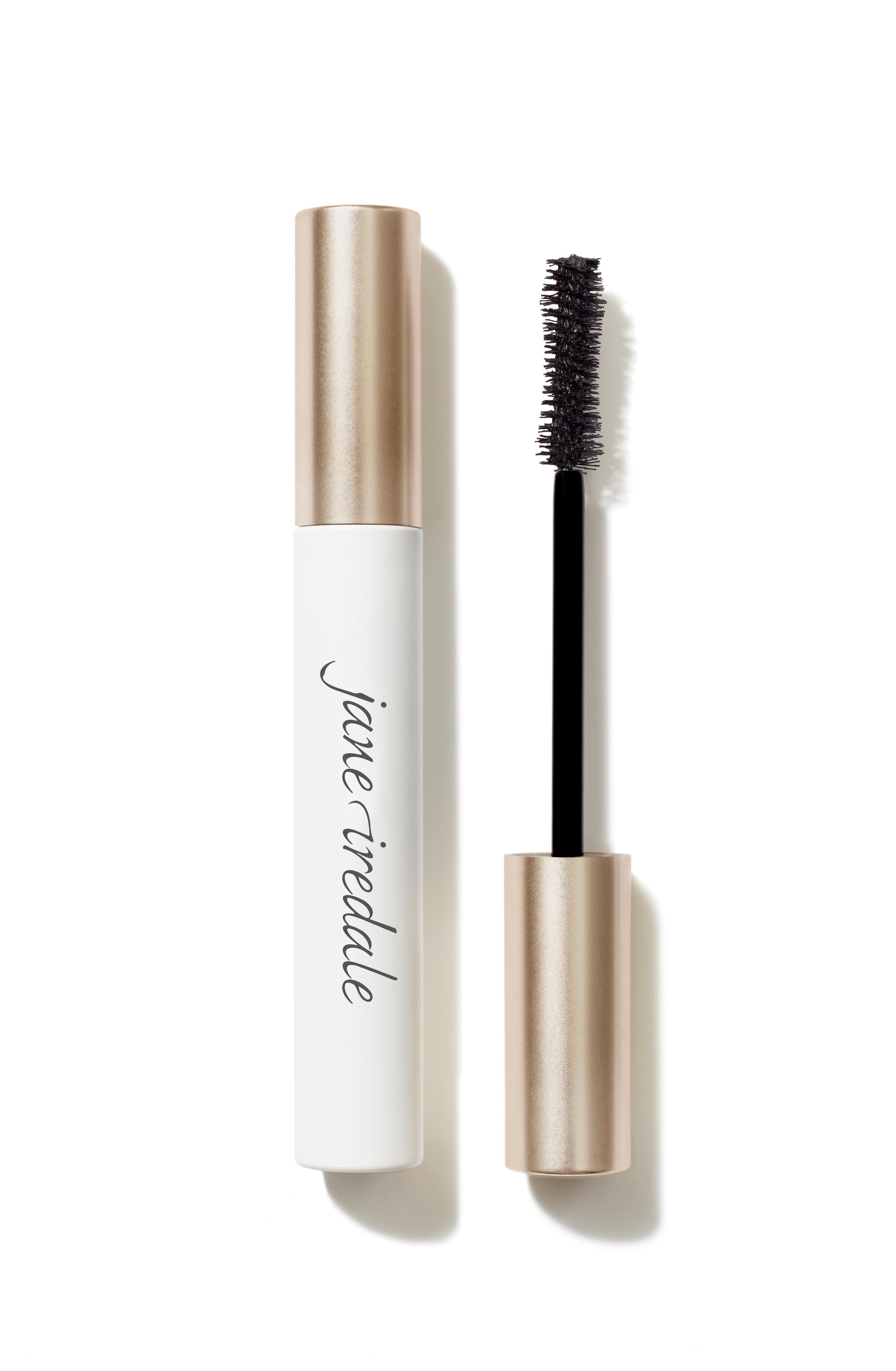 Beyond Lash™ Volumizing Mascara with a black bristle brush and white-and-rose-gold tube, offering buildable, naturally derived, nourishing volume.