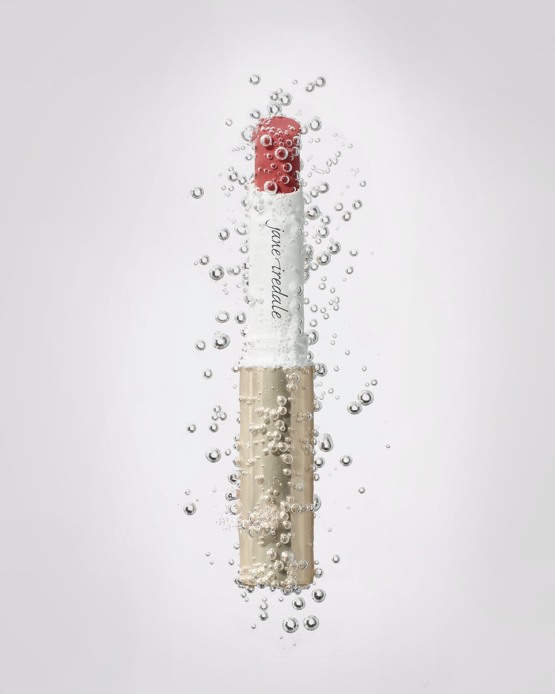 ColorLuxe Hydrating Cream Lipstick by jane iredale, underwater with bubbles, offers rich, vibrant color and hydration with a luxurious satin finish.