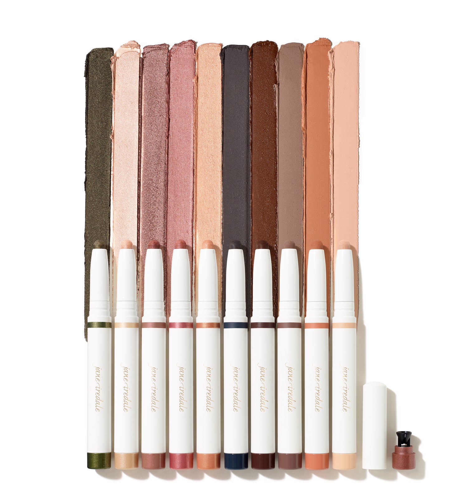 ColorLuxe Eye Shadow Stick: Row of twist-up cream eyeshadow sticks by Jane Iredale, showcasing swatched shades, with an open cap featuring a built-in sharpener.