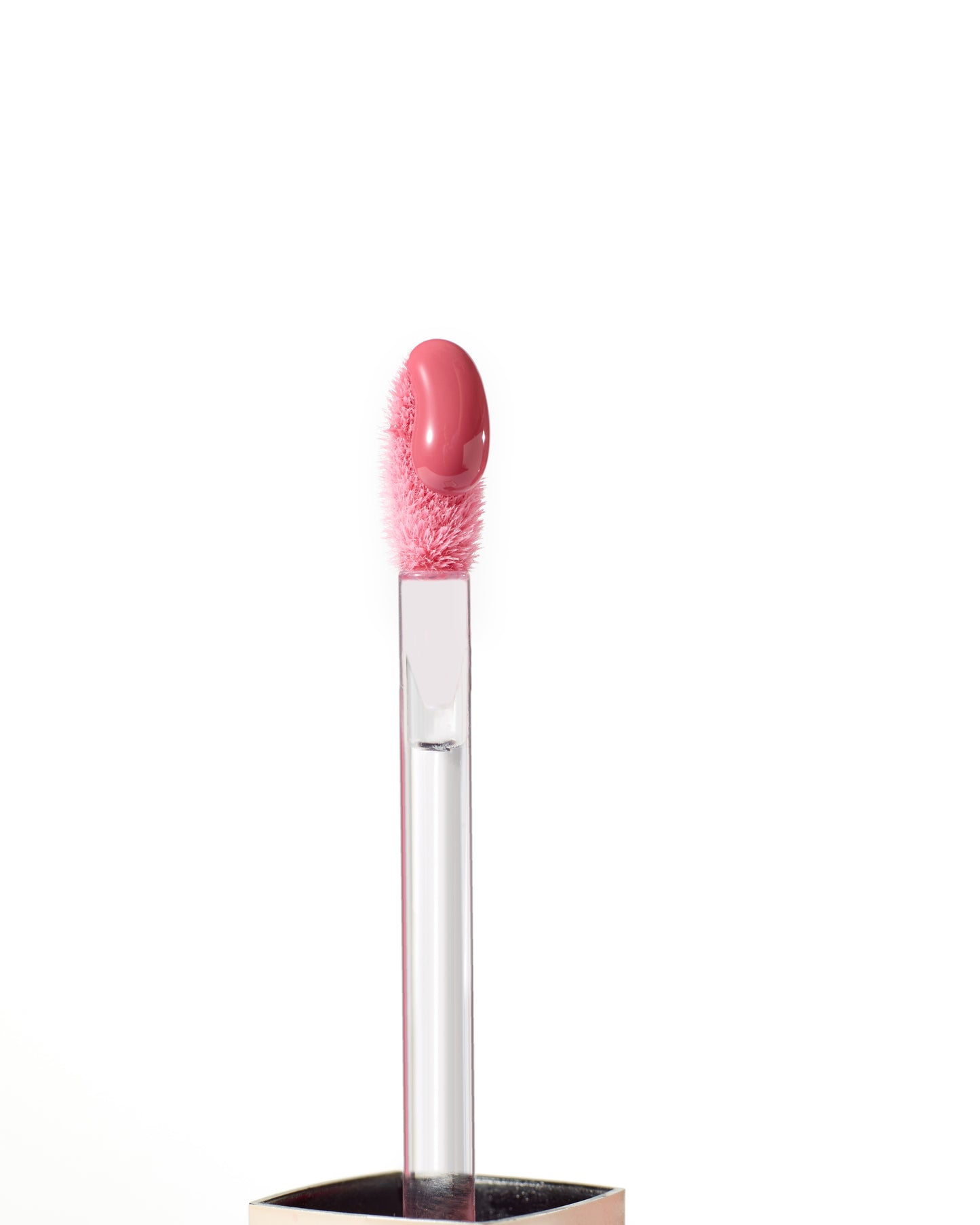 ColorLuxe High Impact Lip Glaze applicator with pink gloss on fuzzy tip, showcasing its glossy, nourishing formula for bold, comfortable wear.