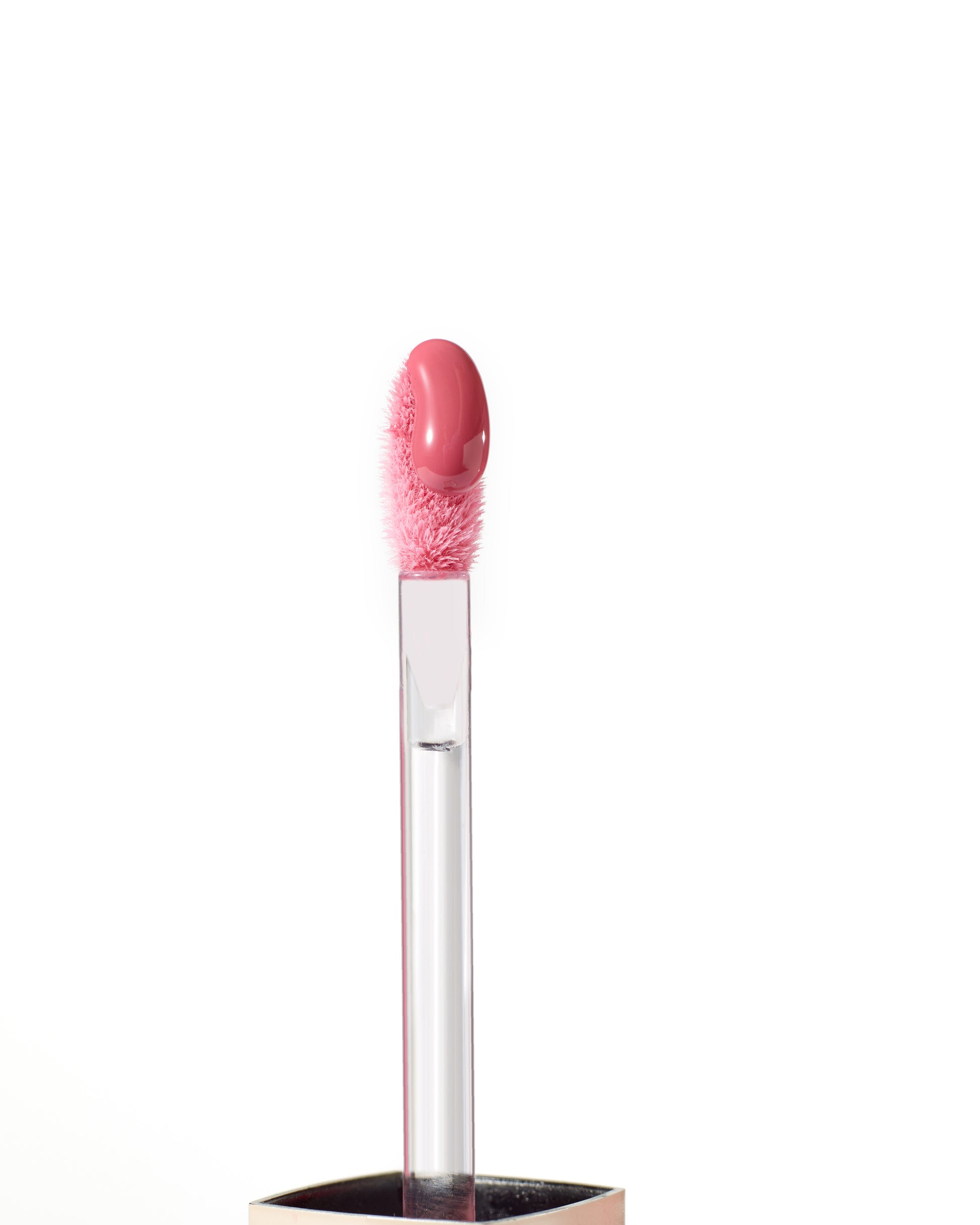 ColorLuxe High Impact Lip Glaze applicator with pink gloss on fuzzy tip, showcasing its glossy, nourishing formula for bold, comfortable wear.