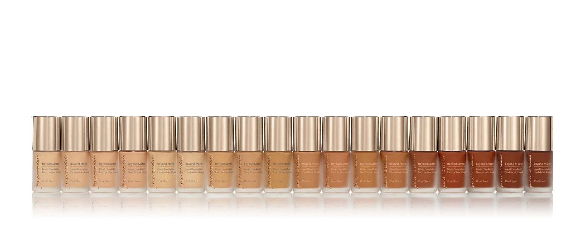 Row of frosted-glass bottles of Beyond Matte™ Liquid Foundation, showcasing a full skin-tone shade range in sleek design with metallic caps.