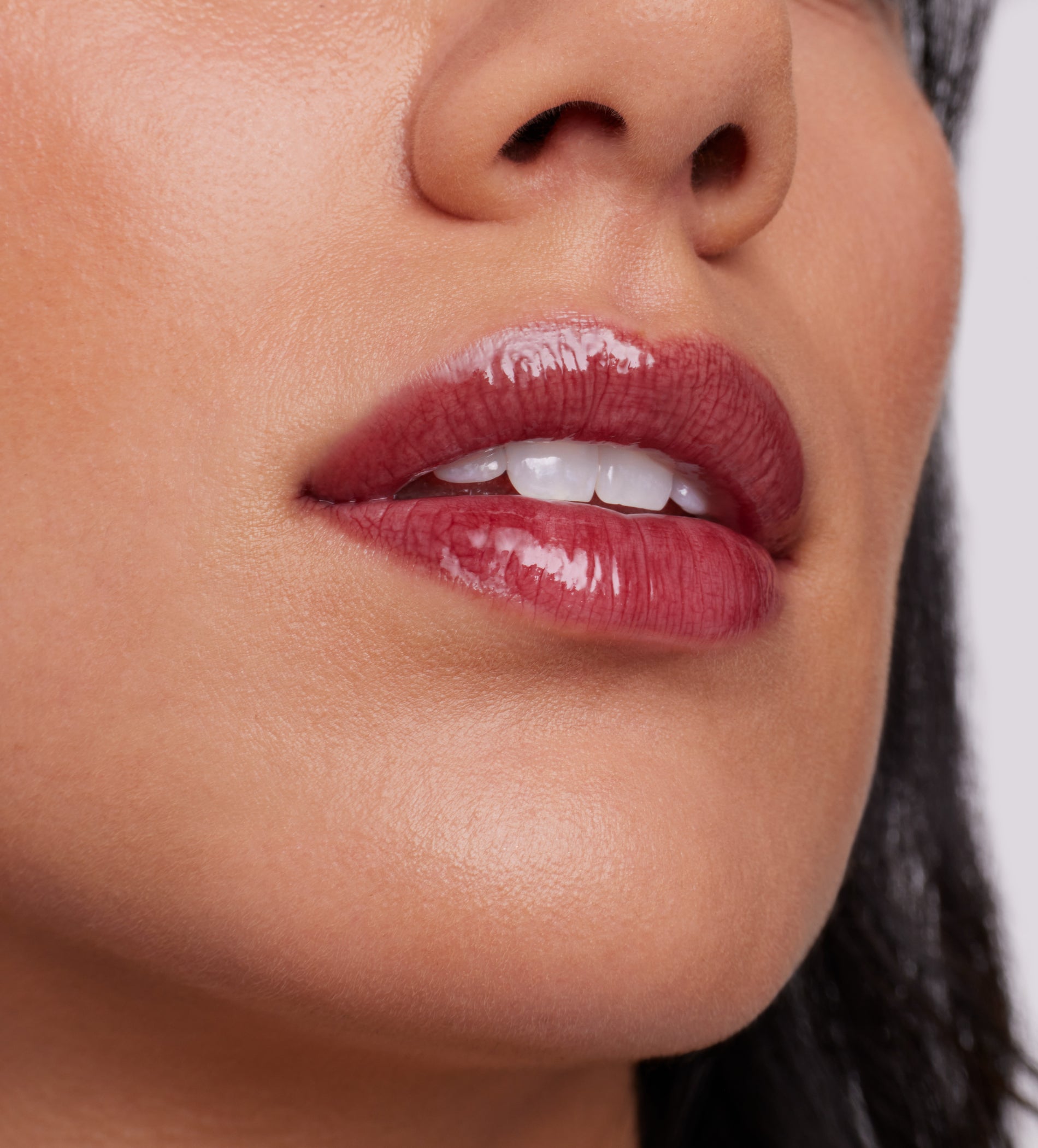 Close-up of glossy deep-red lips wearing ColorLuxe High Impact Lip Glaze, showcasing vibrant color and shine with a nourishing, smooth finish.