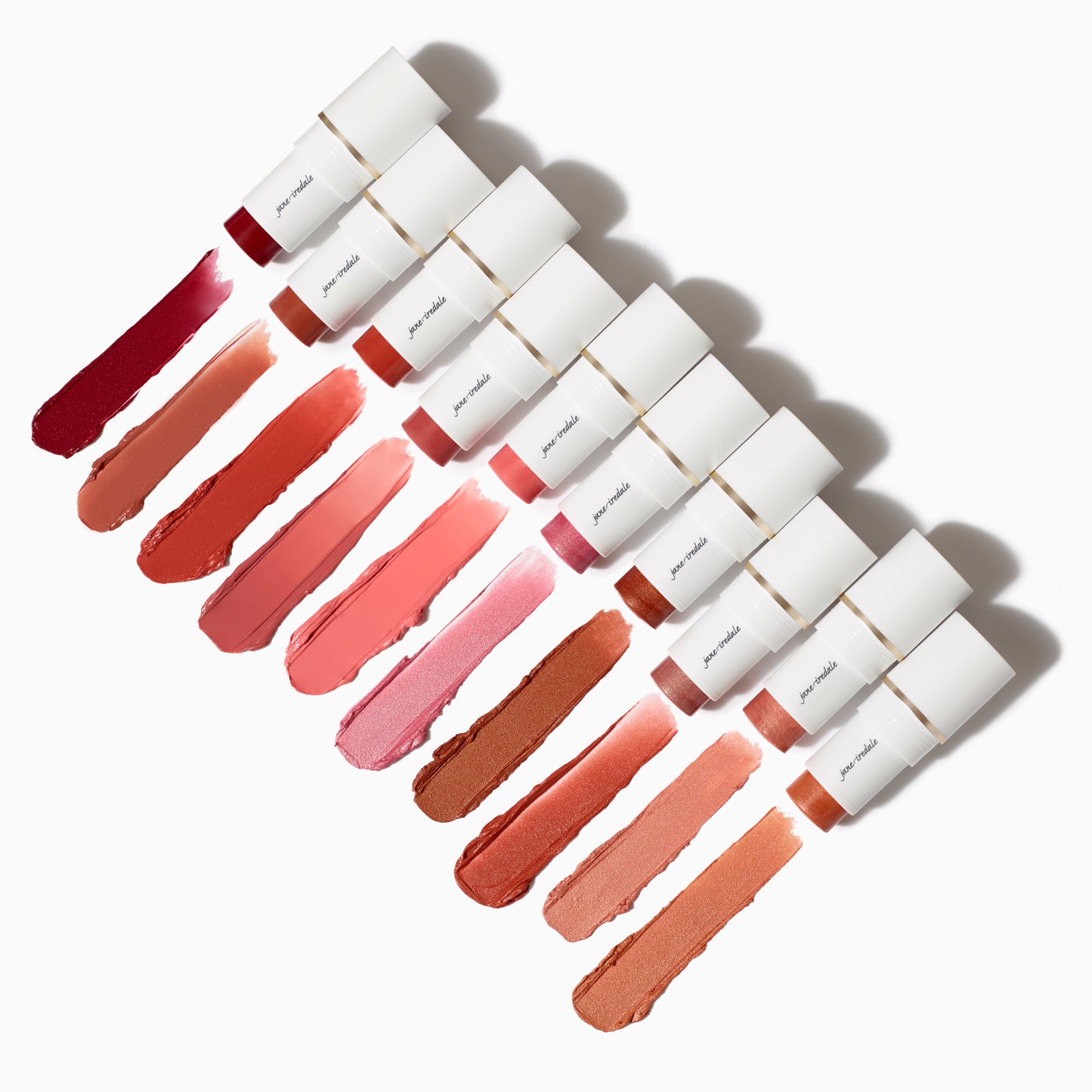 Ten Glow Time® Blush Sticks displayed diagonally, showcasing creamy pigments from berry to nude-peach, highlighting their buildable, skin-like finish with nourishing Olive Squalane.