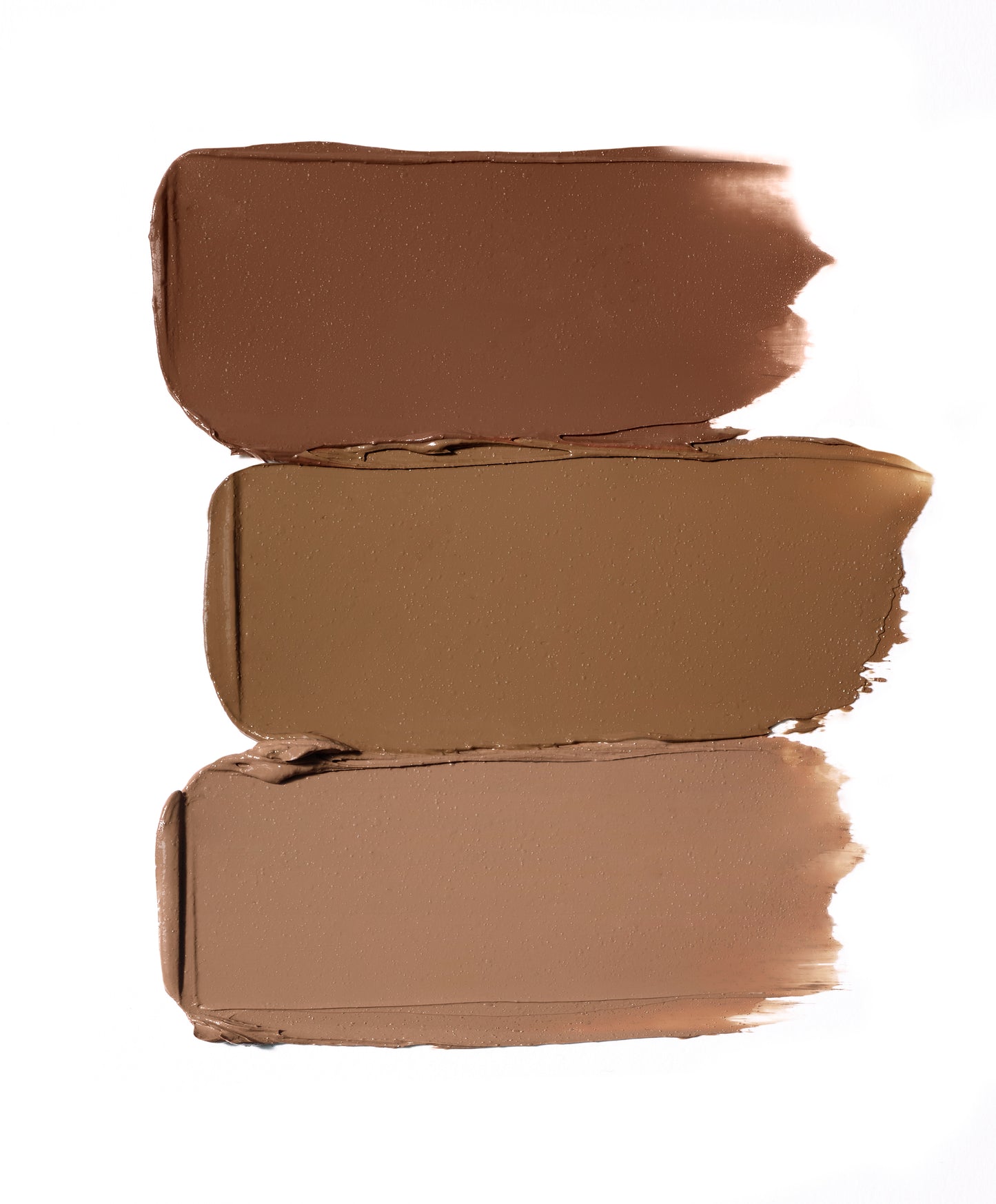 Glow Time® Bronzer Stick swatches in three brown tones, showcasing buildable, creamy formula for a natural, sun-kissed glow.