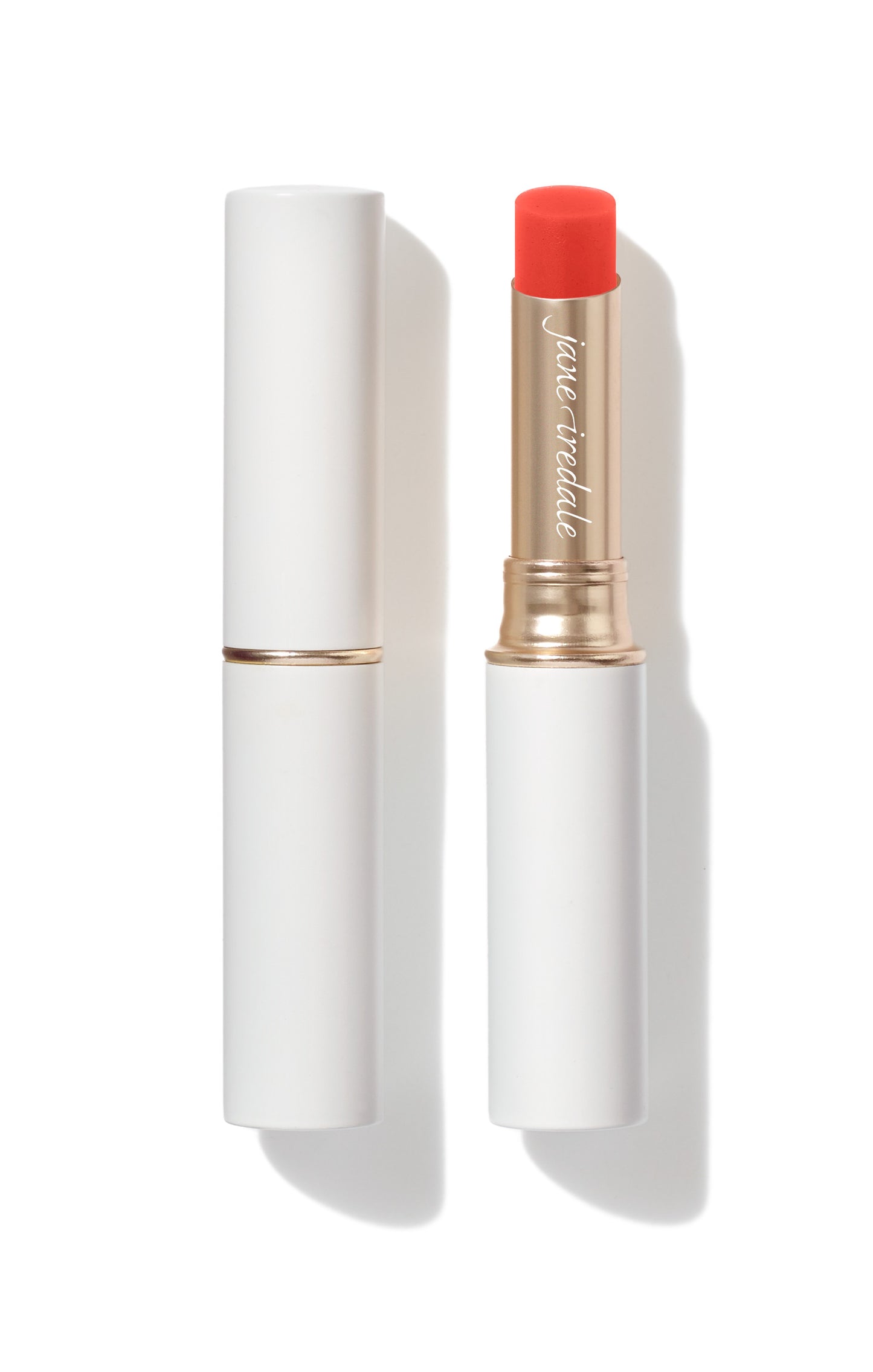 Jane Iredale Just Kissed® Lip and Cheek Stain, featuring a coral-red cream stick in an open white tube, multitasks with nourishing oils for personalized color.