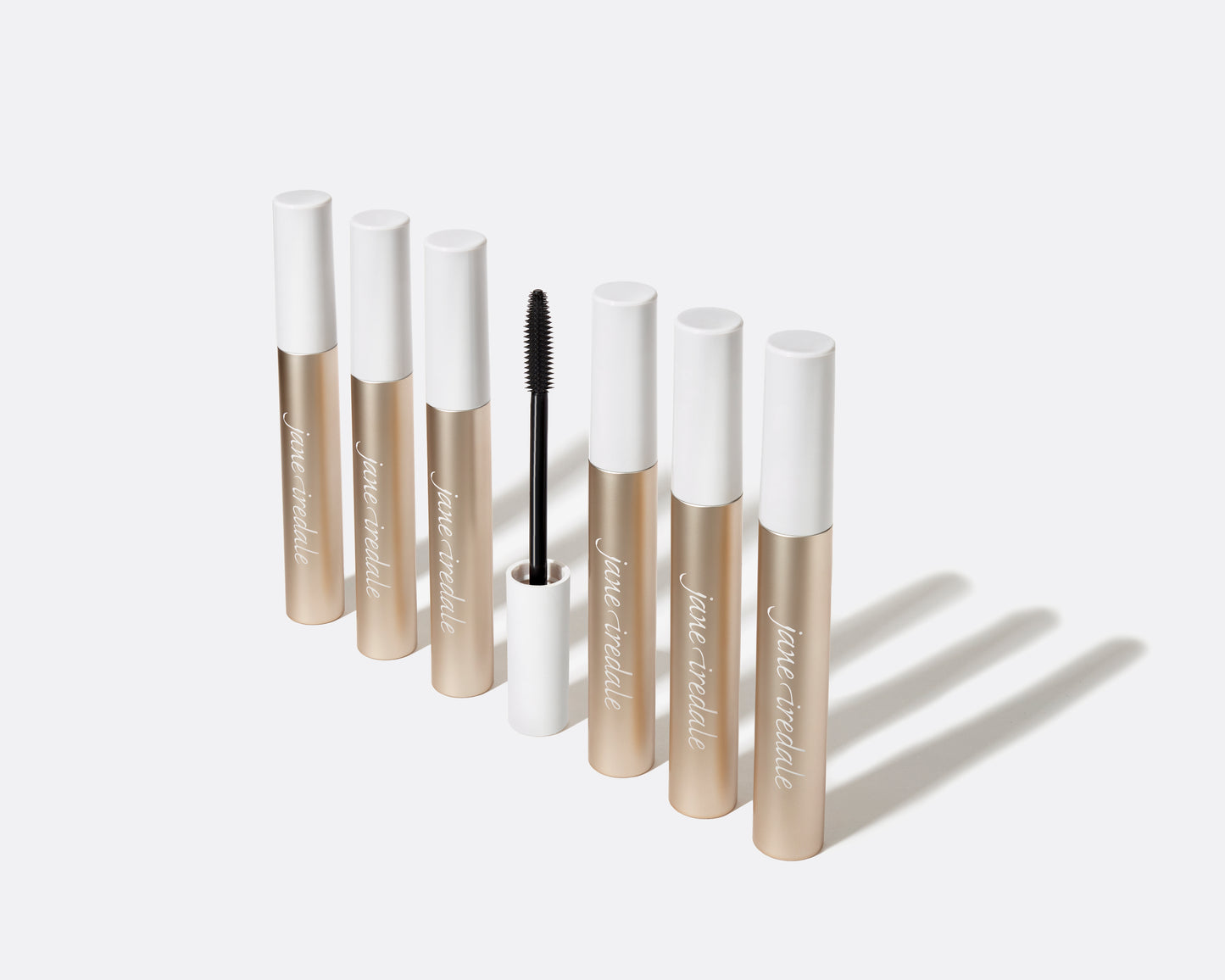 jane iredale Lash Fixation Length & Definition Tubing Mascara showing seven gold tubes, one open, highlighting its lengthening, smudge-proof formula and easy removal.