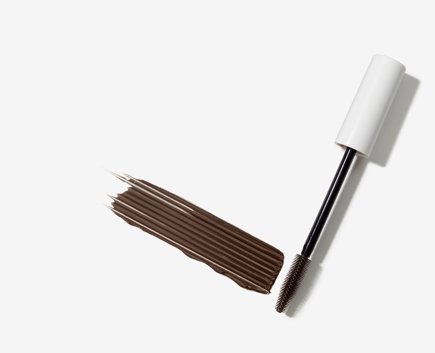 Lash Fixation Length & Definition Tubing Mascara wand with narrow, spiked brush and brown swatch, highlighting lengthening, smudge-proof formula for defined, clump-free lashes.