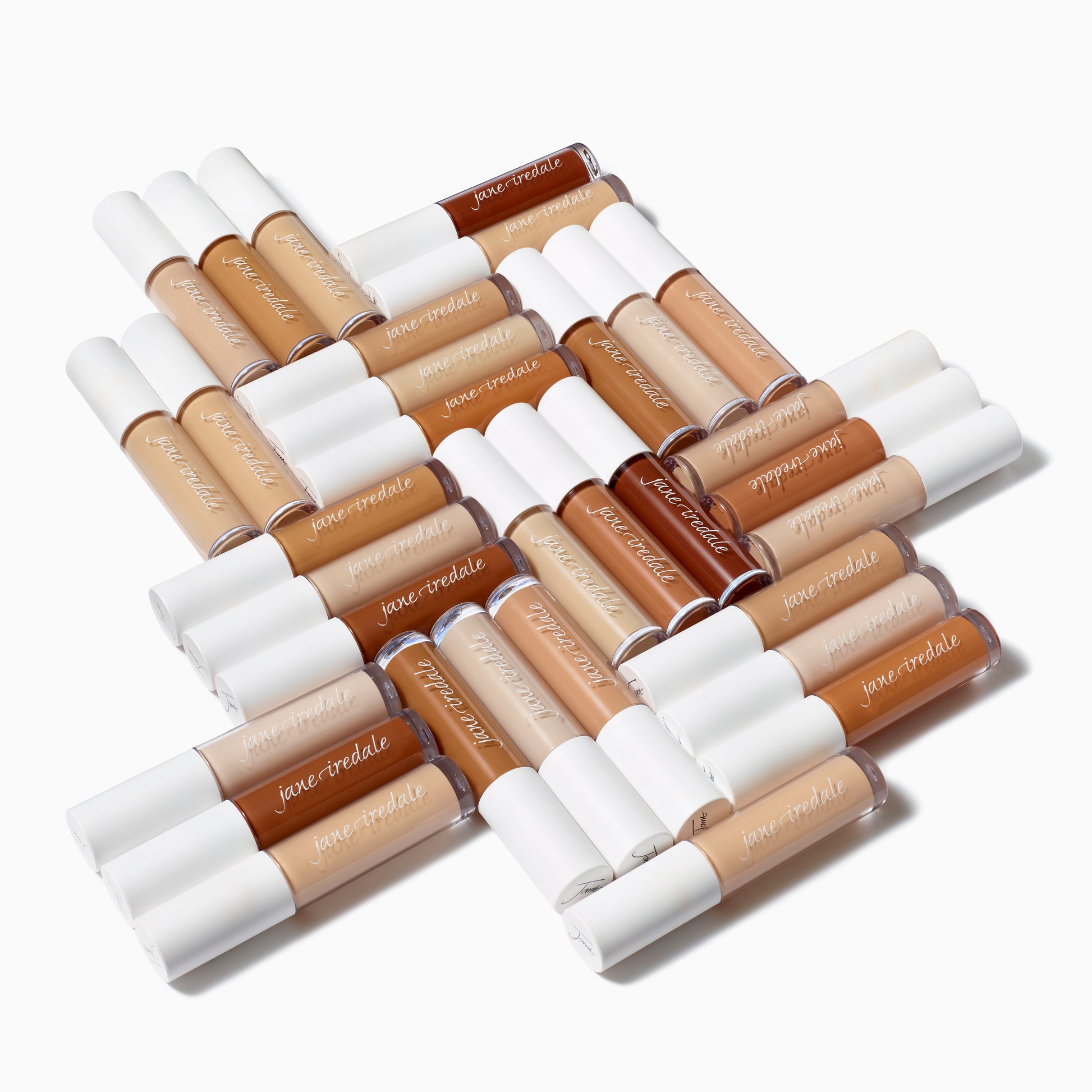 PureMatch™ Liquid Concealer tubes arranged in a plus-sign, showcasing a diverse, inclusive 16-shade range for natural, buildable coverage with a seamless finish.
