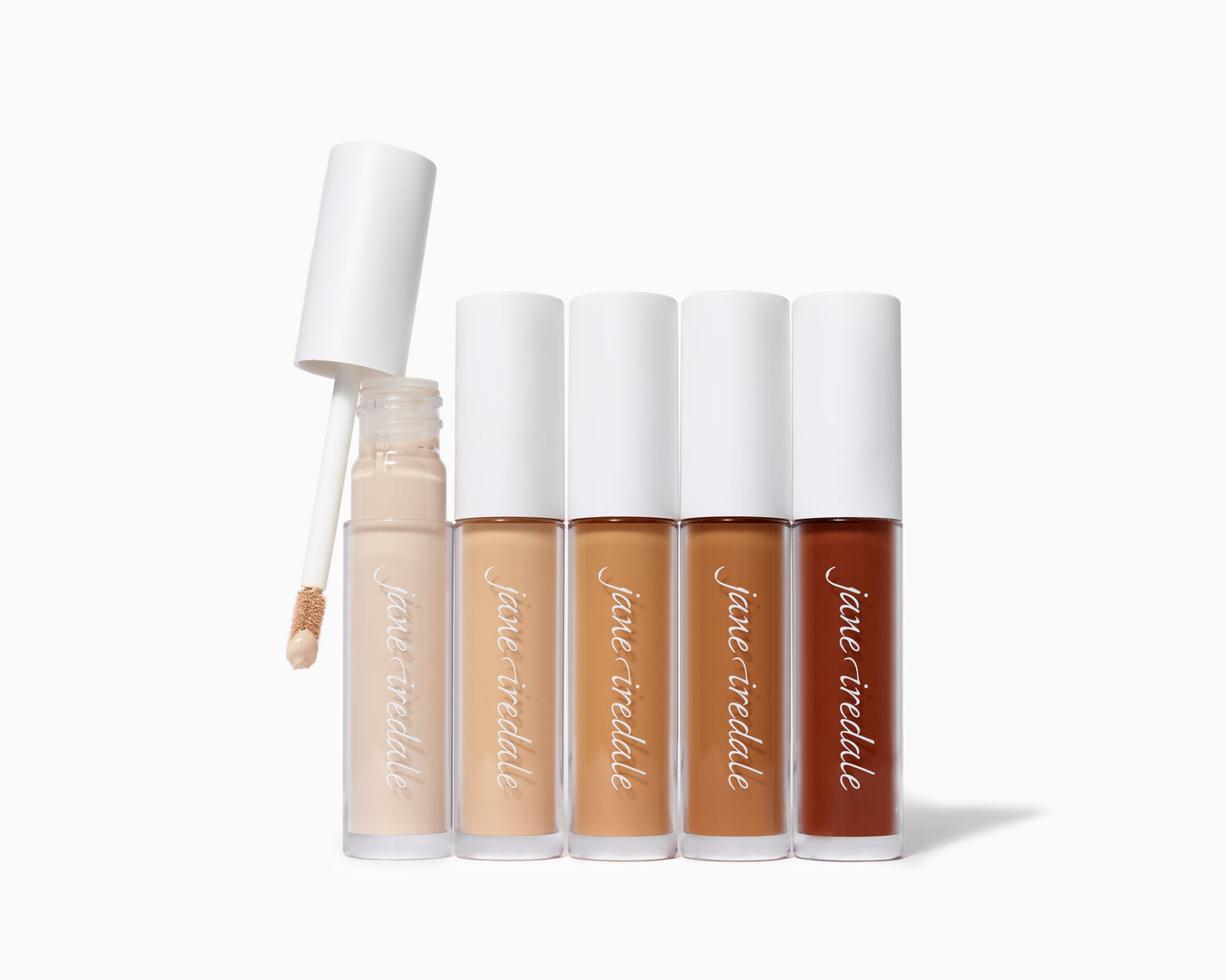 Five tubes of PureMatch™ Liquid Concealer, ranging from light to deep brown, with a doe-foot applicator shown, ideal for seamless, buildable coverage.