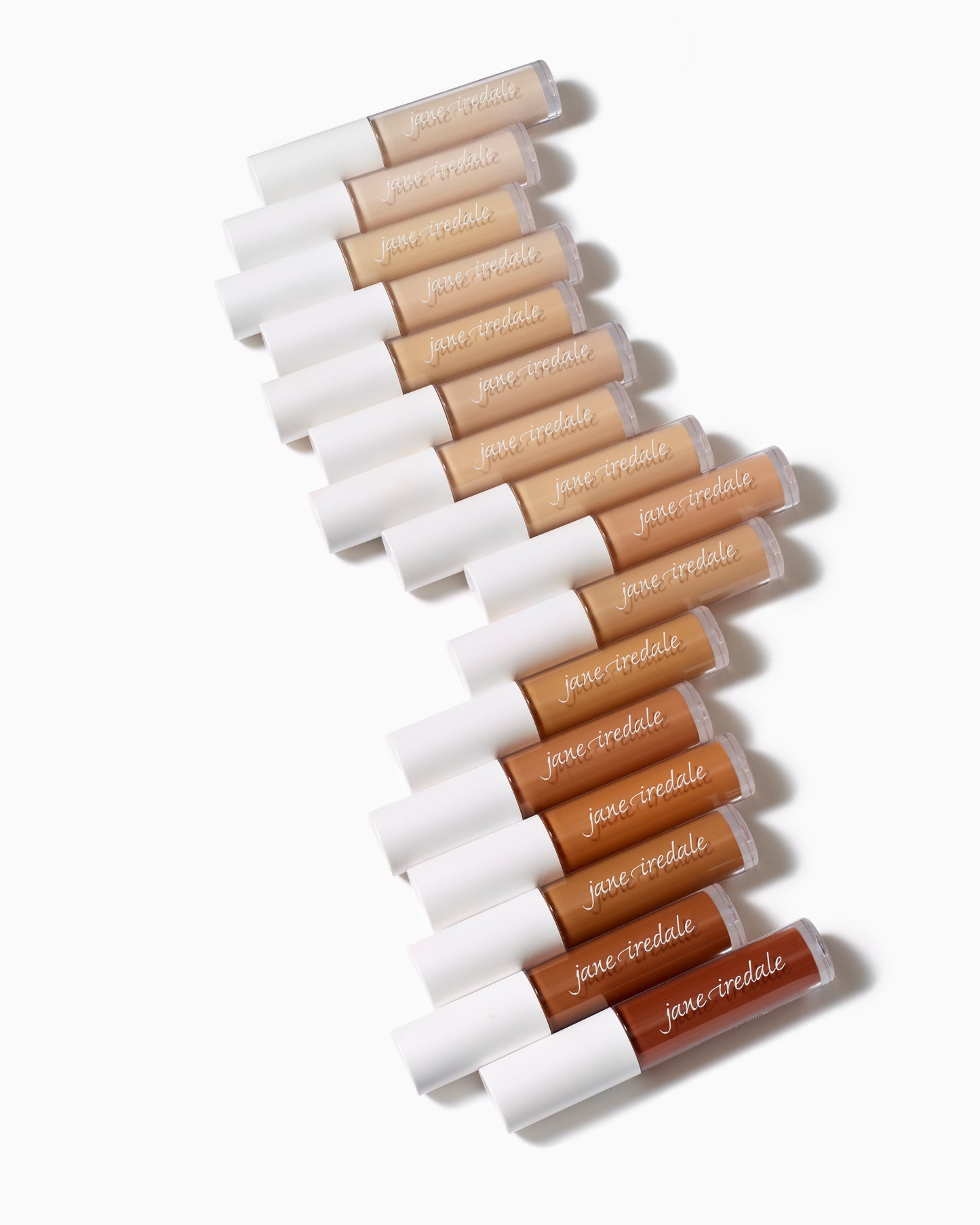 Jane Iredale PureMatch™ Liquid Concealer tubes, showcasing diverse shades, arranged in a diagonal line, highlighting buildable coverage and natural finish for inclusive skin tones.