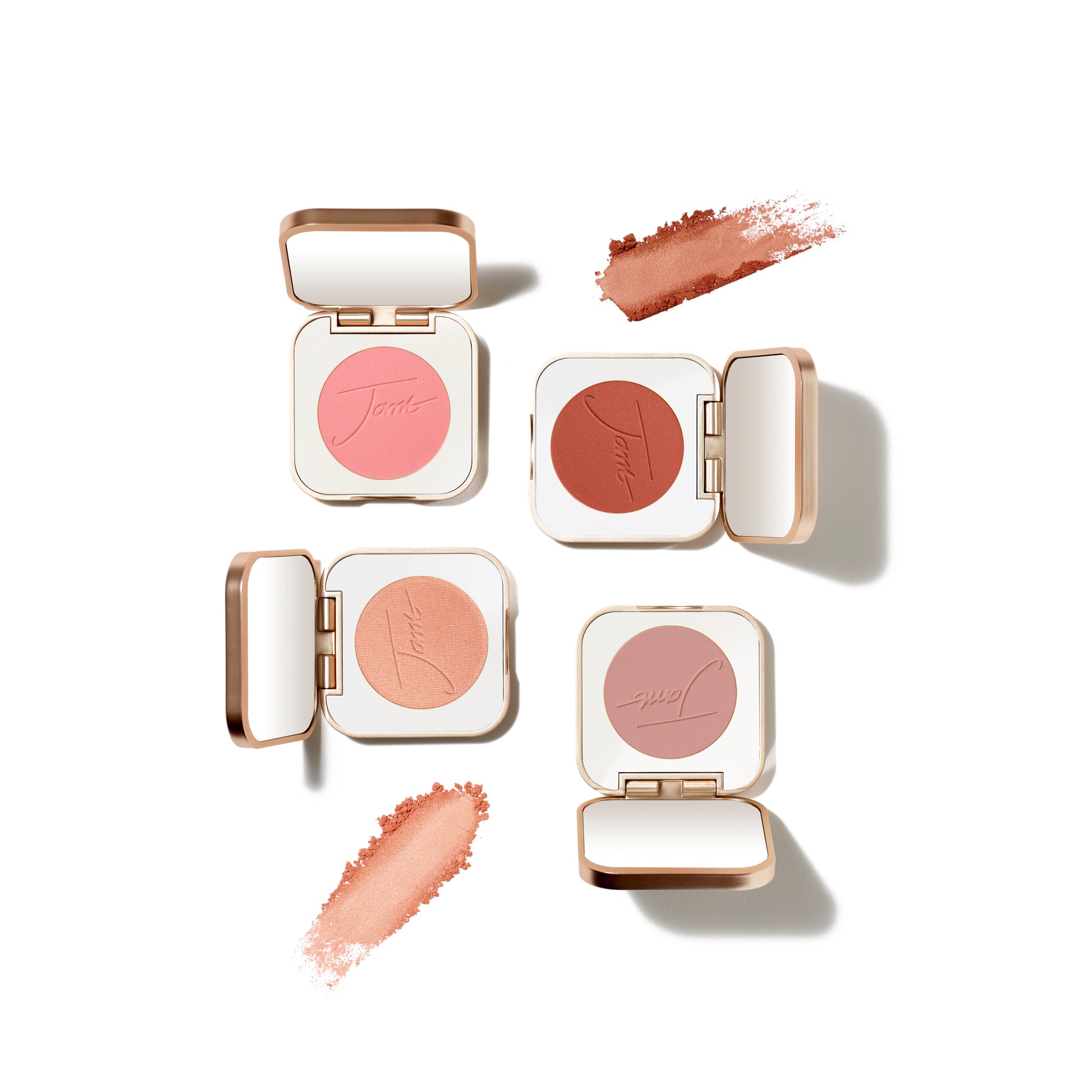 PurePressed® Blush compacts in four shades, with swipes of loose powder, showcasing a silky, buildable mineral formula for a natural flush.