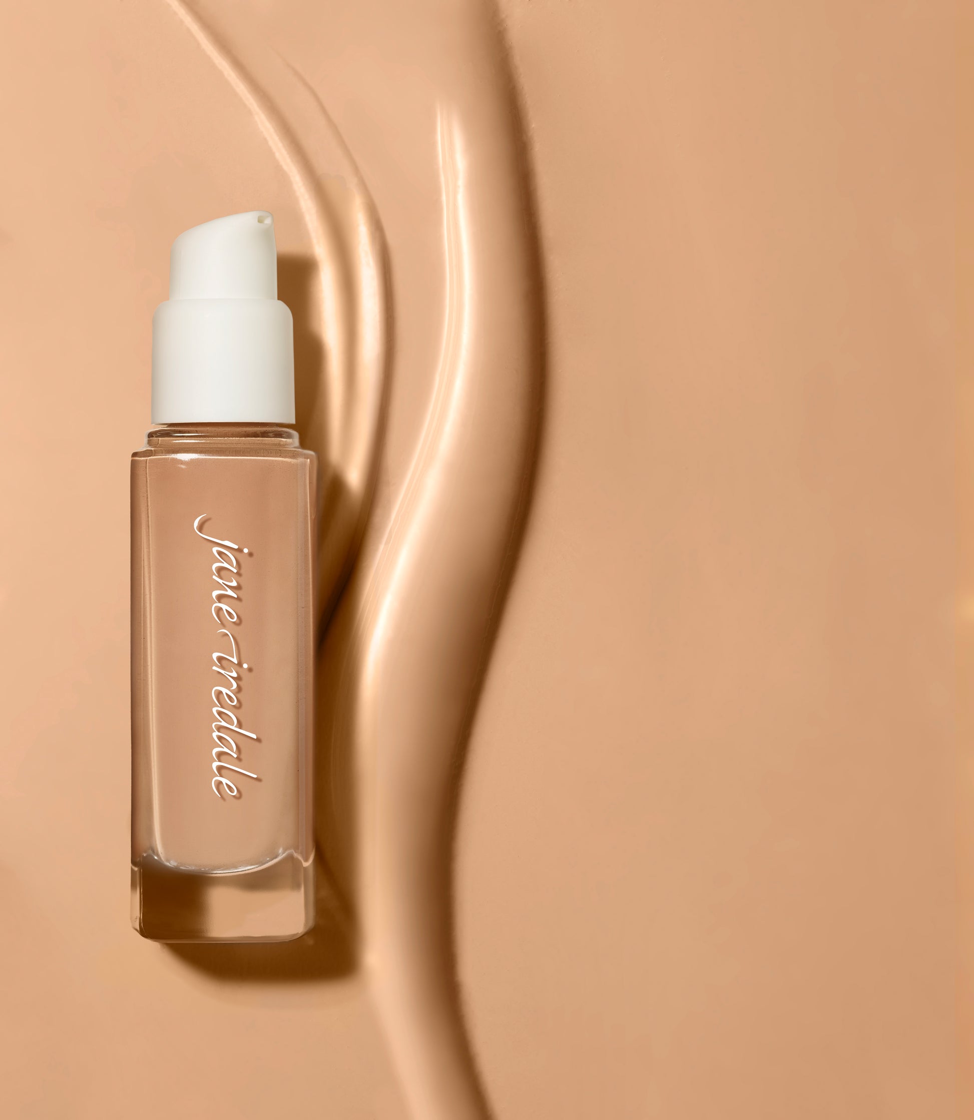 Jane Iredale Skintuition SPF 30 Radiance-Boosting Liquid Foundation in a pump-top glass bottle, showcased with artistic product swipes on a beige background.