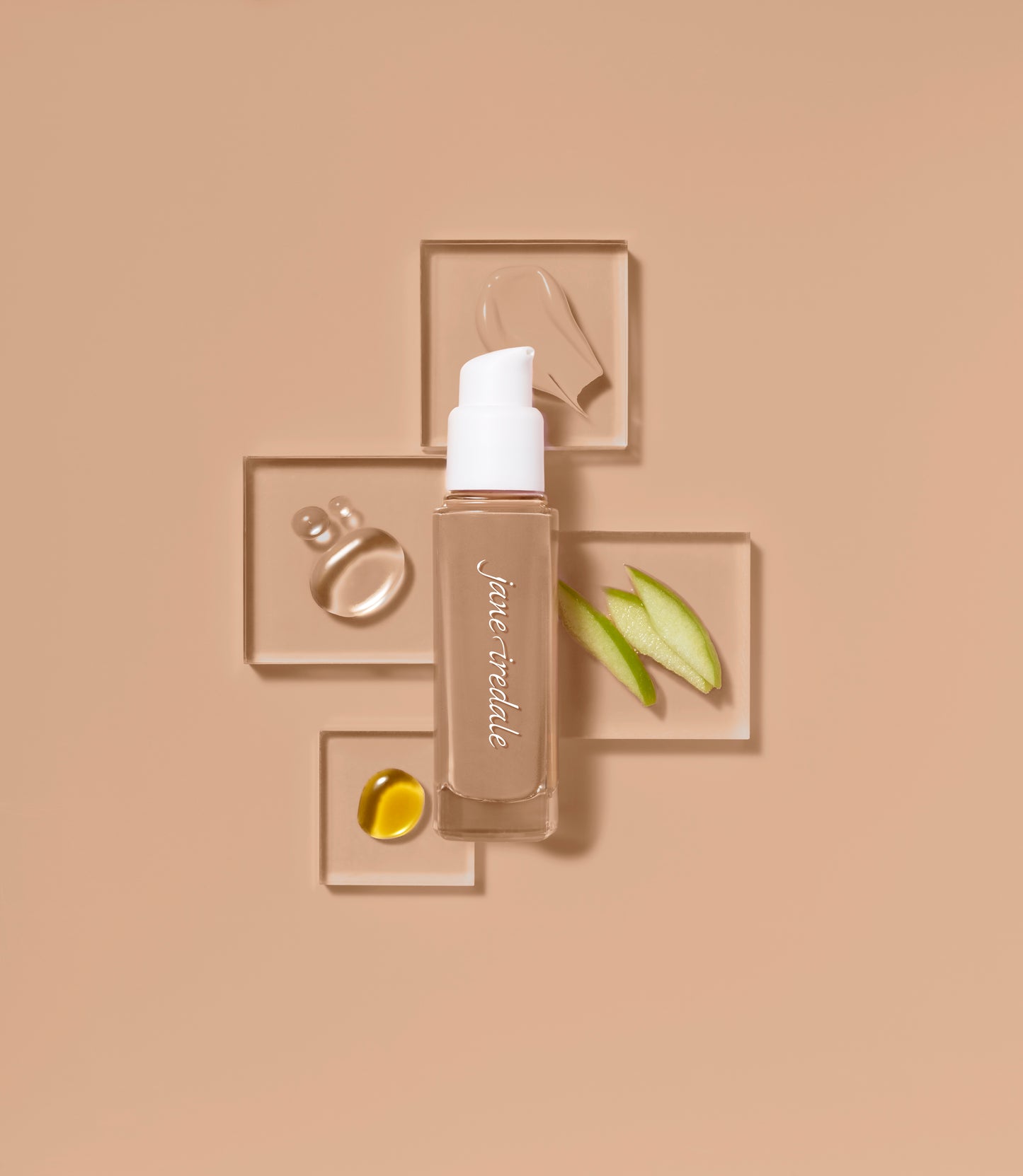 Jane Iredale Skintuition SPF 30 Radiance-Boosting Liquid Foundation bottle, styled with gel, oil, foundation smear, and green apple slices, highlighting its natural and nourishing ingredients.