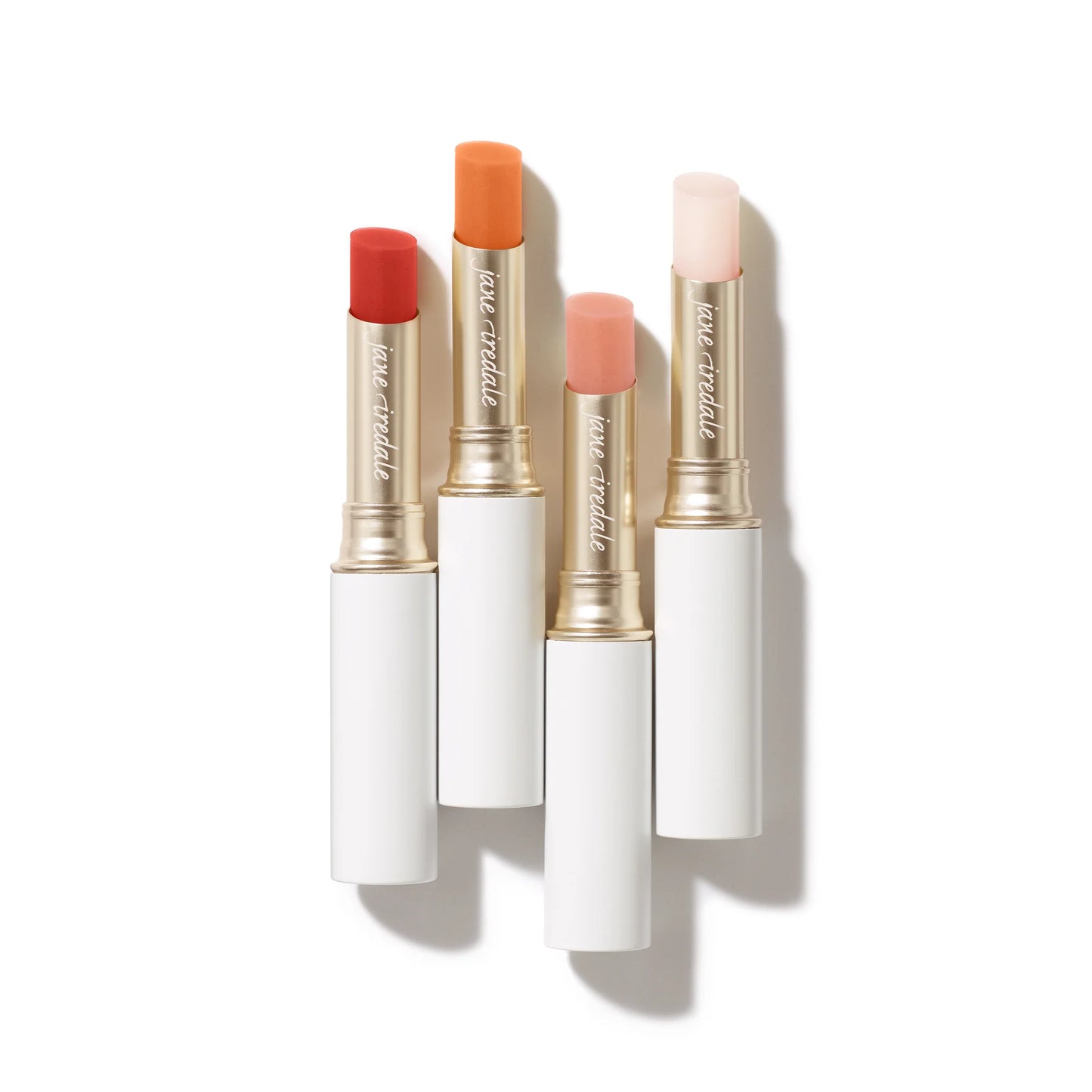 Just Kissed® Lip and Cheek Stain sticks in white and gold tubes, showcasing four shades for personalized pH-based color, enriched with nourishing oils.