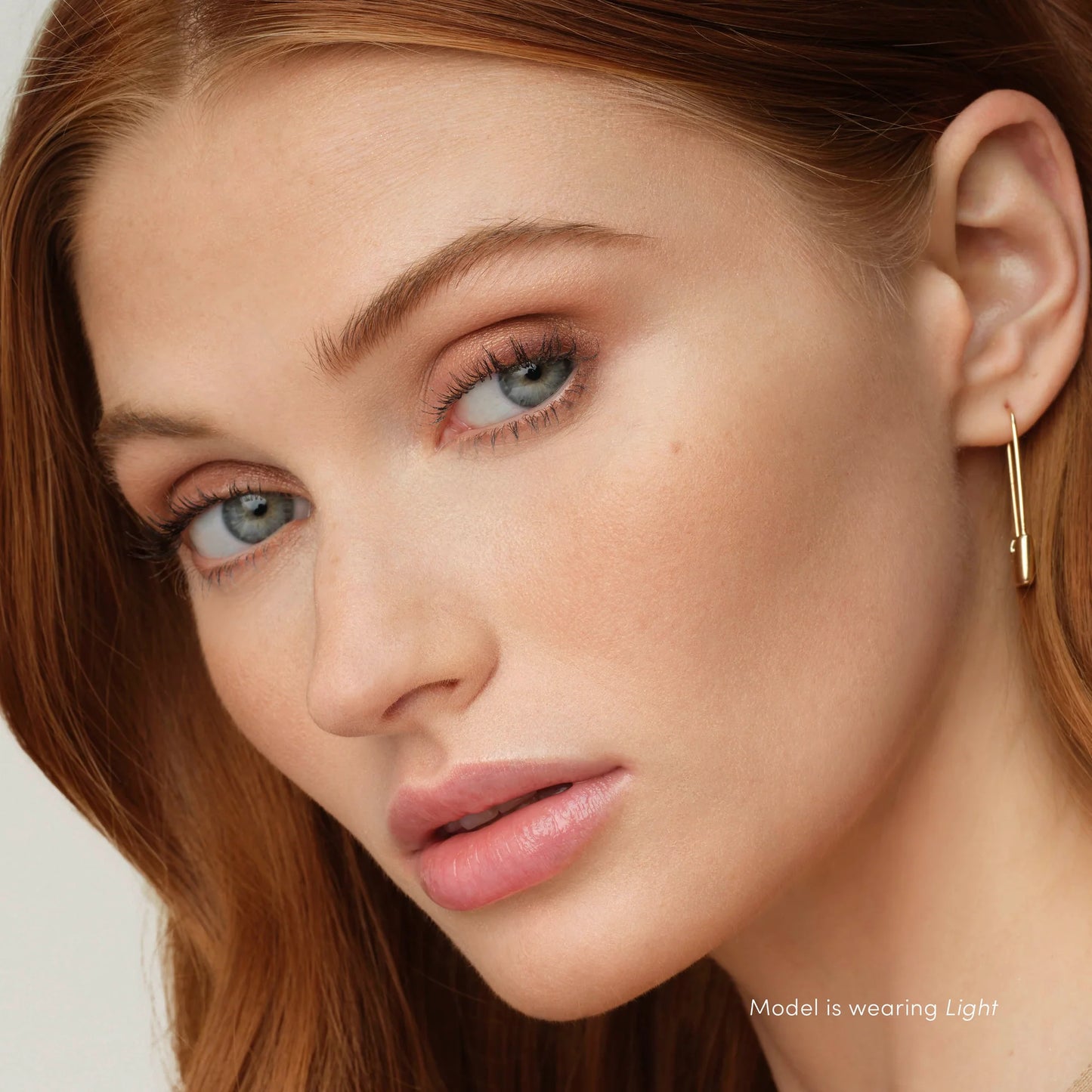 Close-up of a woman showcasing PureBronze™ Matte Bronzer Powder Refill, highlighting her sun-kissed complexion with even foundation and natural makeup finish.