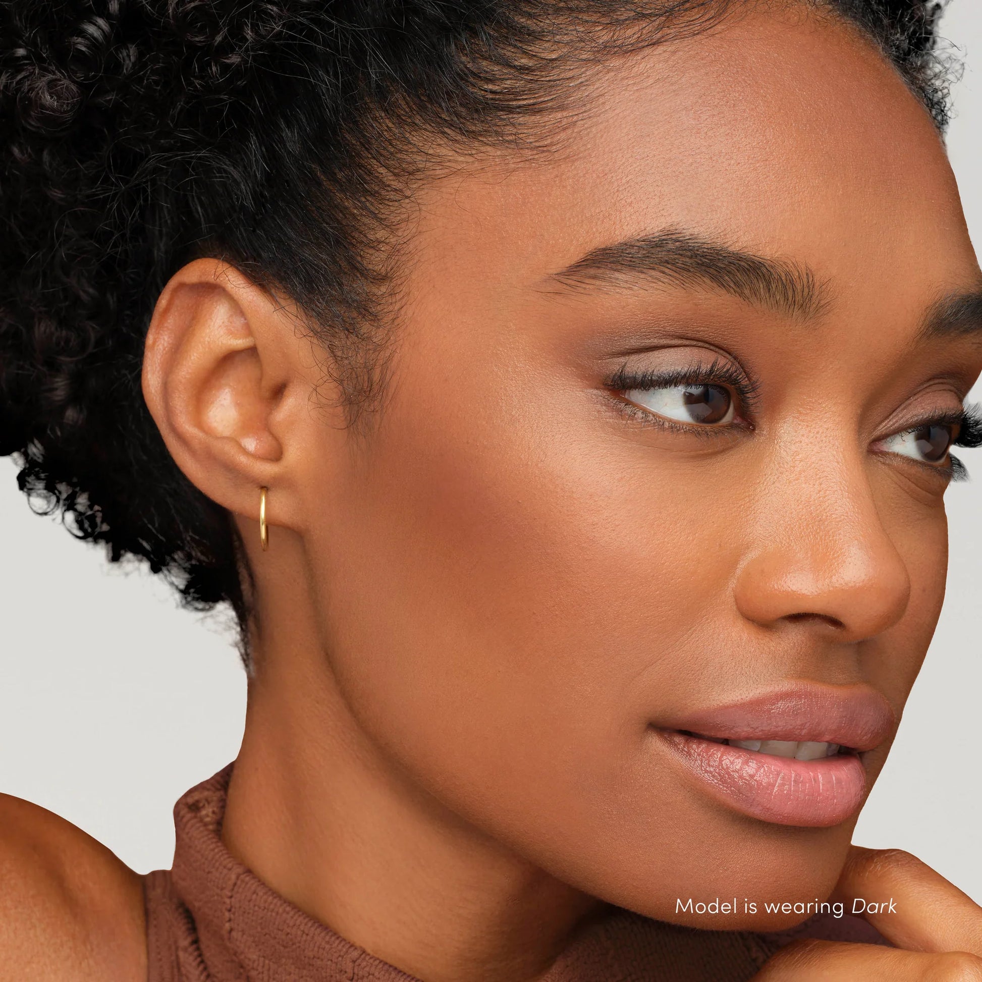 Close-up of a woman's face wearing PureBronze™ Matte Bronzer Powder Refill in Dark, showcasing a natural, sun-kissed finish with subtle contouring.