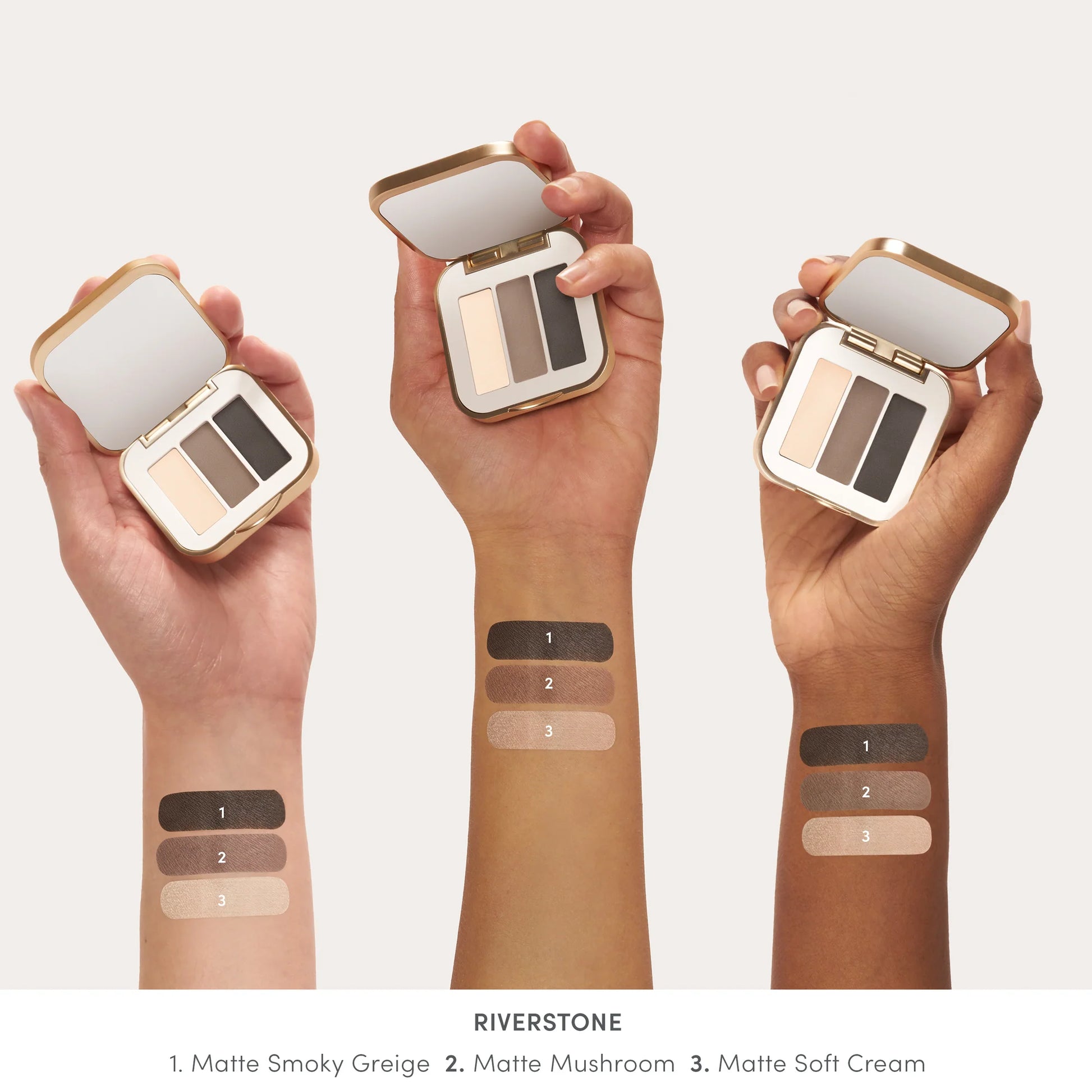 PurePressed® Eye Shadow Triple RIVERSTONE in an open gold-edged compact, showcasing three matte shades swatched on three different skin tones.