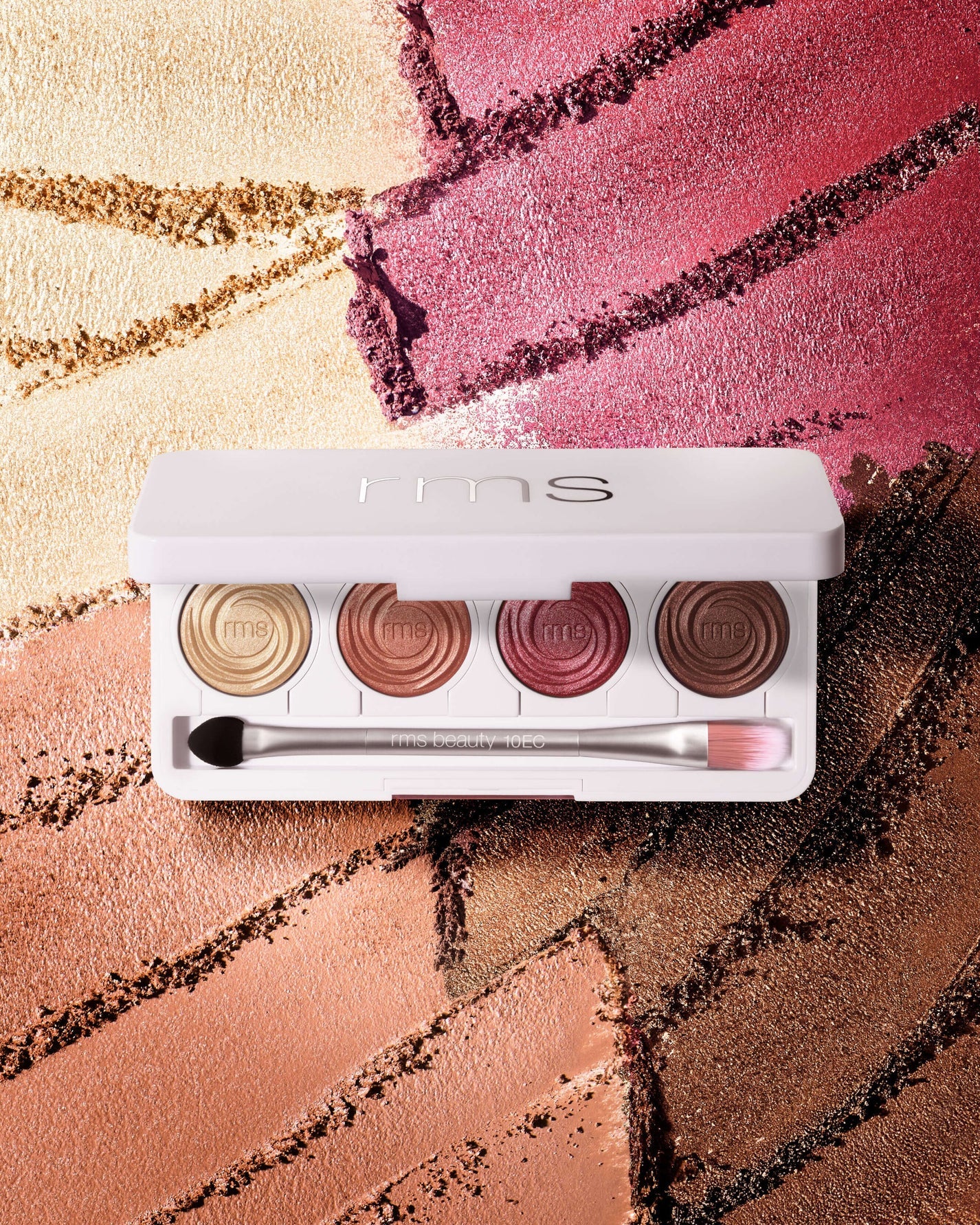 rms beauty ReDimension Hydra Eyes Quartet, a white compact with four shimmery eyeshadows and dual-ended applicator, on a backdrop of matching metallic shadows.