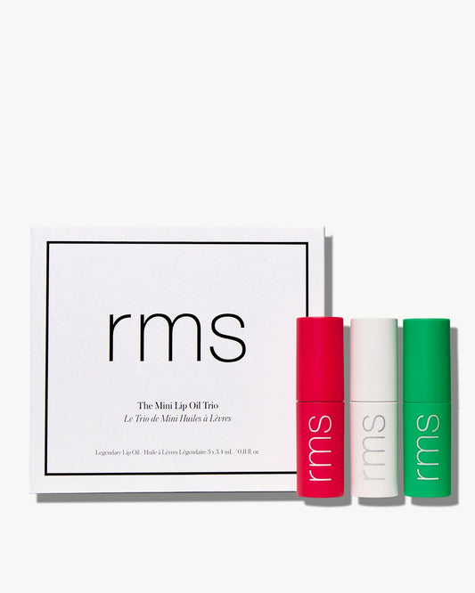 Boxed set of RMS Beauty’s Mini Lip Oil Trio featuring three mini tubes of lip oil in a branded white box, including shades Lily, Adrianna, and exclusive Chameleon.
