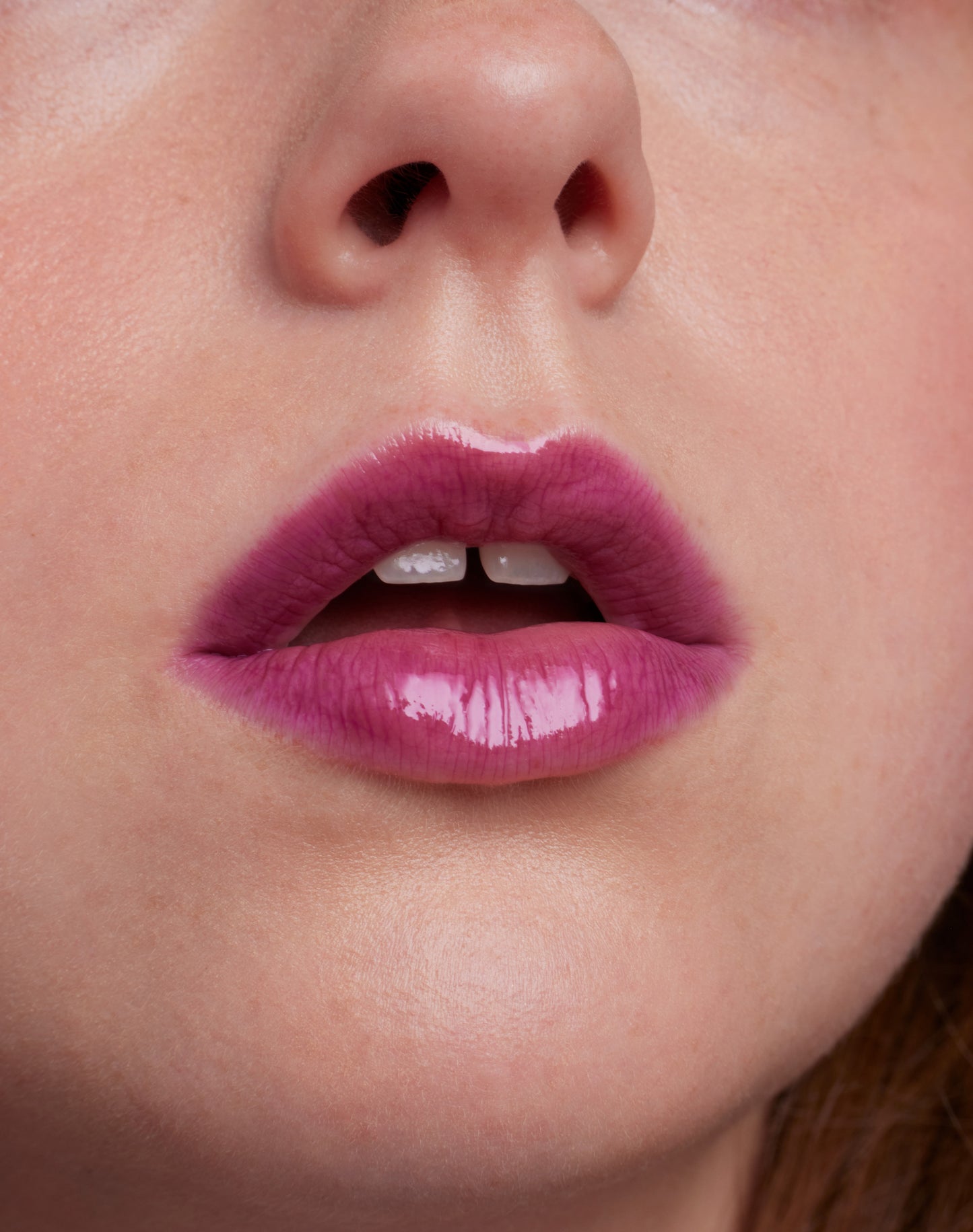 Close-up of lips wearing ColorLuxe High Impact Lip Glaze, showcasing its glossy, bold finish and nourishing formula for a vibrant, long-lasting look.