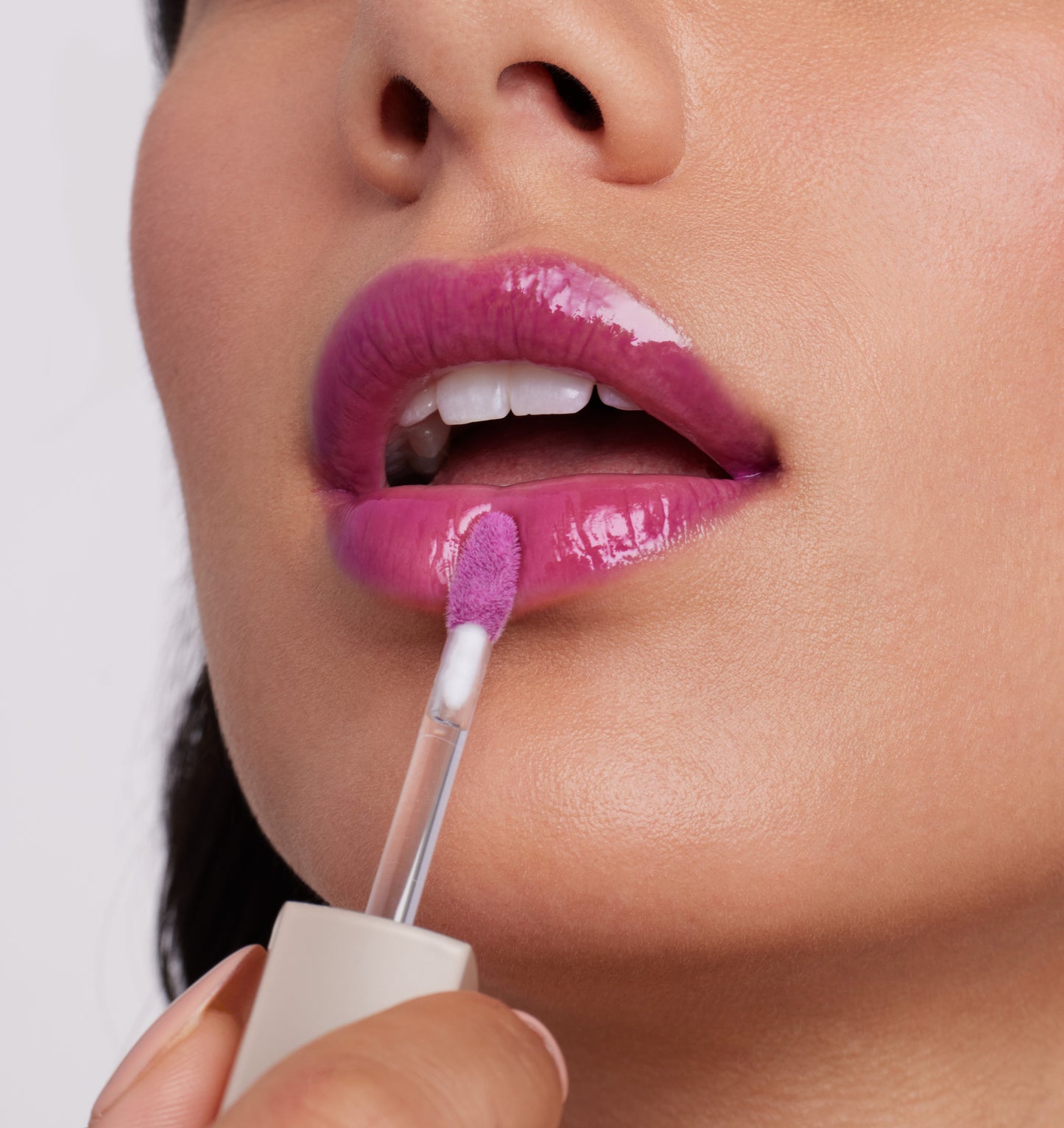 Applying ColorLuxe High Impact Lip Glaze, showcasing its glossy, high-pigment finish on lips with a doe-foot applicator, offering bold, comfortable wear.