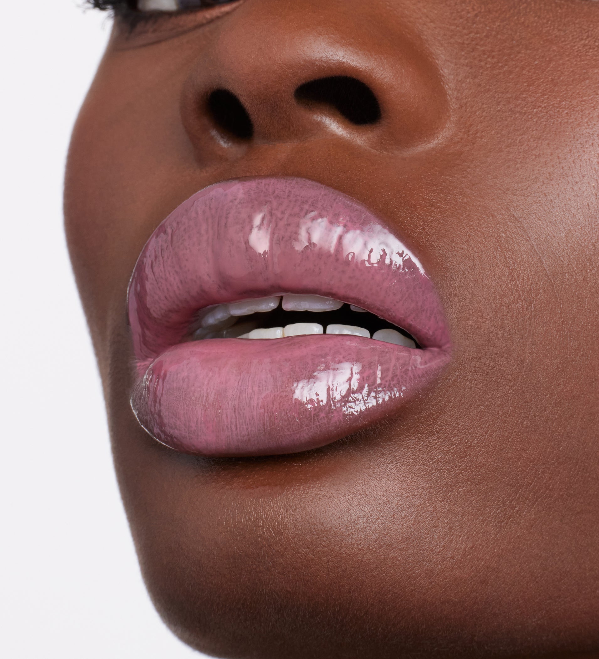Close-up of glossy pink lips wearing ColorLuxe High Impact Lip Glaze, highlighting its vibrant color and shine, ideal for a bold, nourishing statement look.