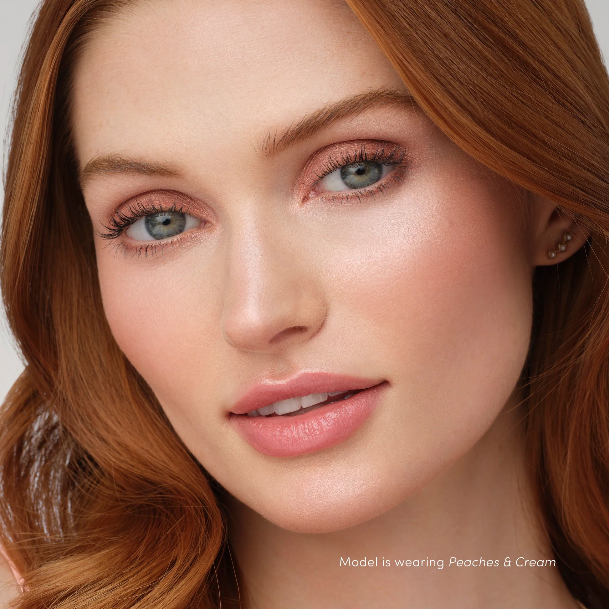 Model showcasing PureBronze™ Shimmer Bronzer Palette Refill in Peaches & Cream, highlighting peach-toned eyeshadow and glossy lips for a radiant look.