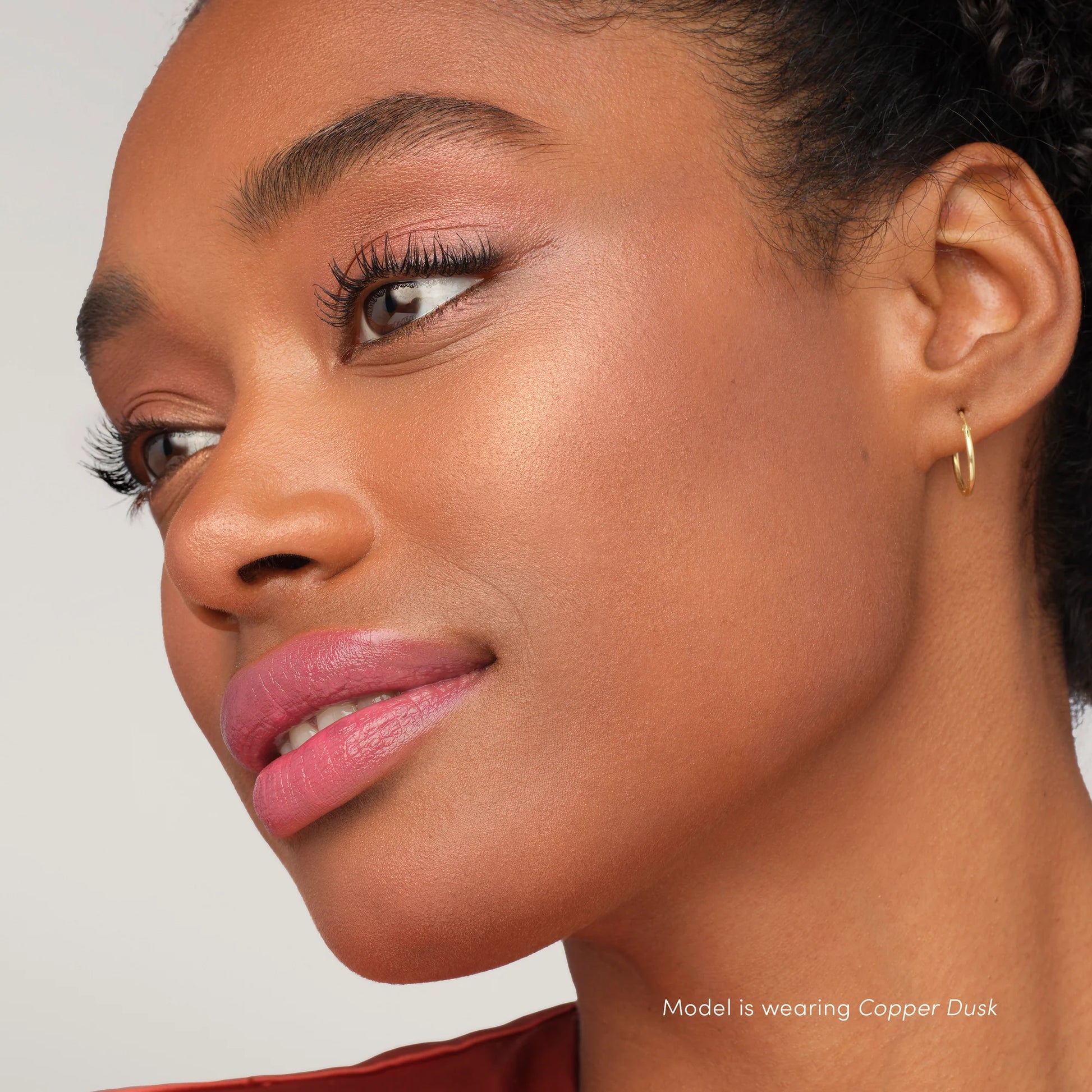 Side profile showing model with copper-toned eyeshadow and bronzy skin using PureBronze™ Shimmer Bronzer Palette Refill, Copper Dusk shade, by Beauty Shop Bellaire.