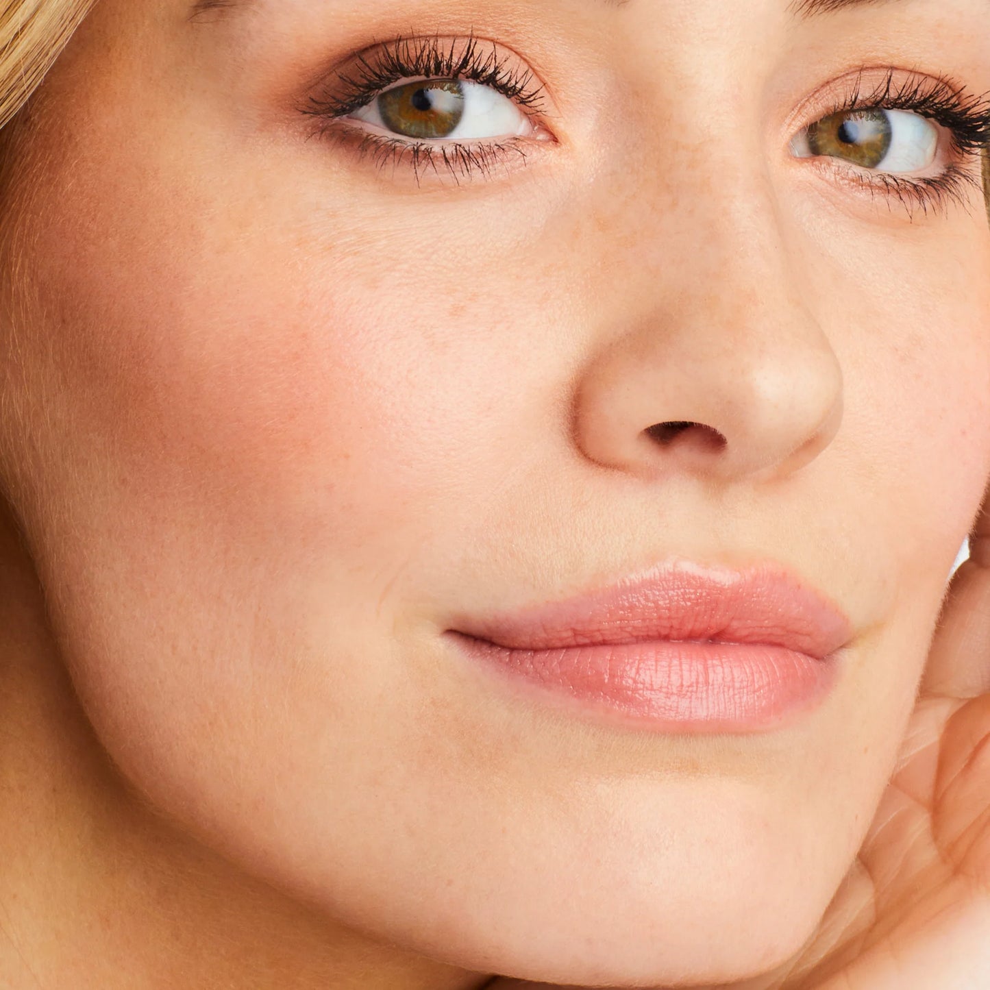 Close-up of a person's face showcasing the natural, skin-like finish of Glow Time® Blush Stick with subtle makeup, emphasizing smooth, hydrated cheeks.