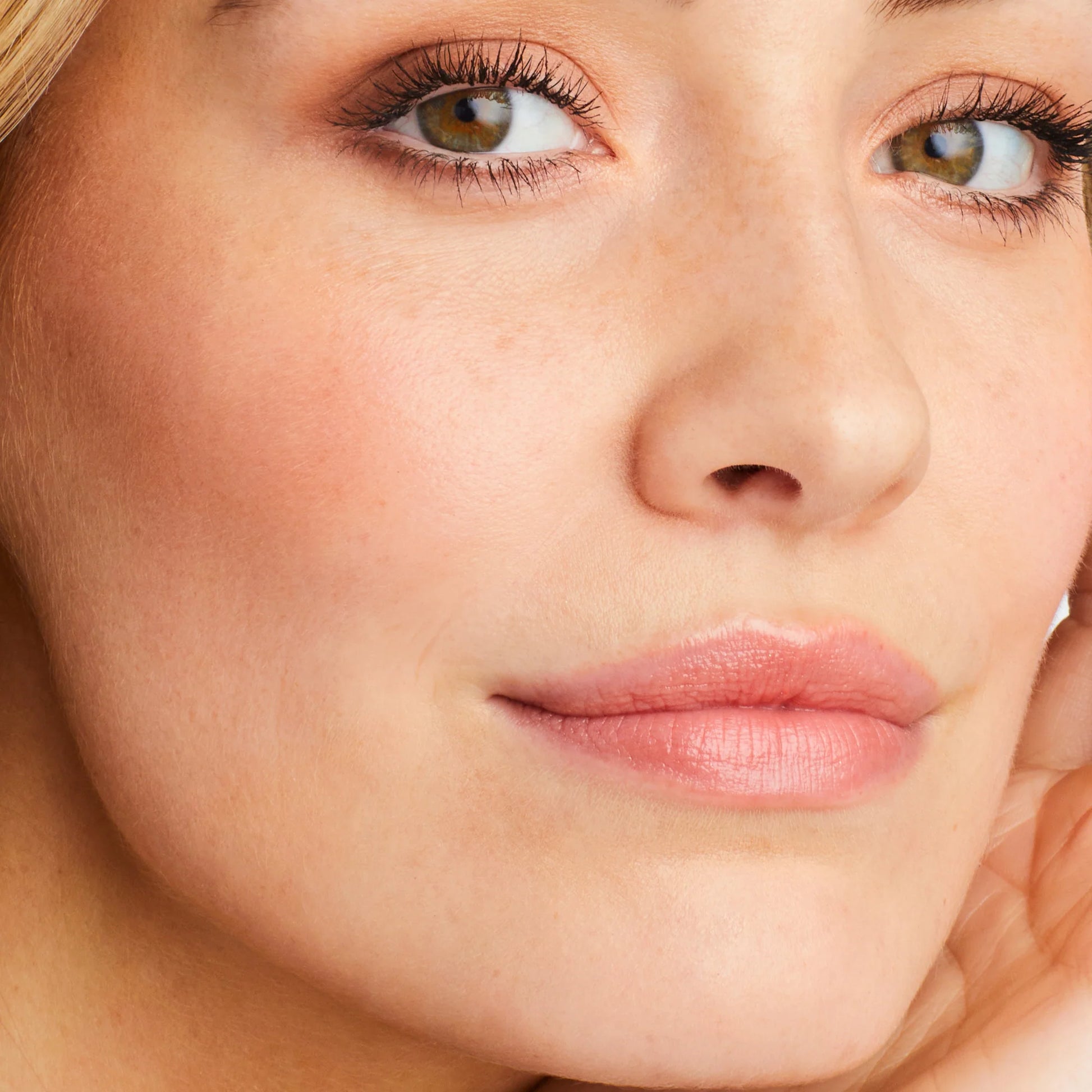 Close-up of a person's face showcasing the natural, skin-like finish of Glow Time® Blush Stick with subtle makeup, emphasizing smooth, hydrated cheeks.