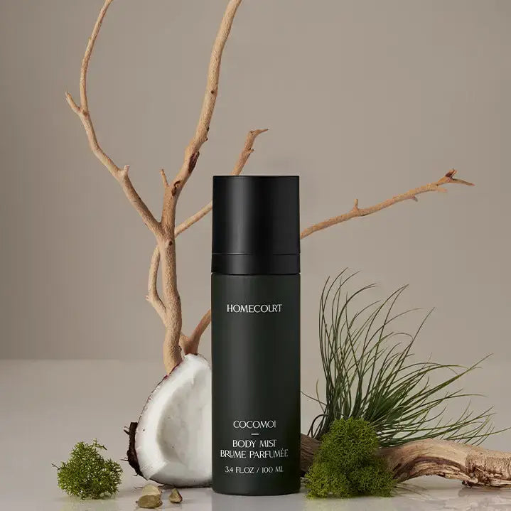 Cocomoi Body Mist | Half Case: Luxurious matte-green bottle amid coconut, driftwood, moss; eco-friendly, sustainable fragrance with coconut water, cedarwood, cardamom notes.