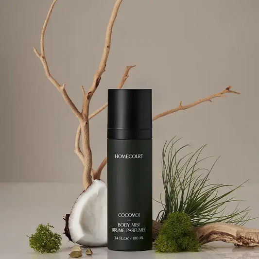 Cocomoi Body Mist | Half Case: Luxurious matte-green bottle amid coconut, driftwood, moss; eco-friendly, sustainable fragrance with coconut water, cedarwood, cardamom notes.