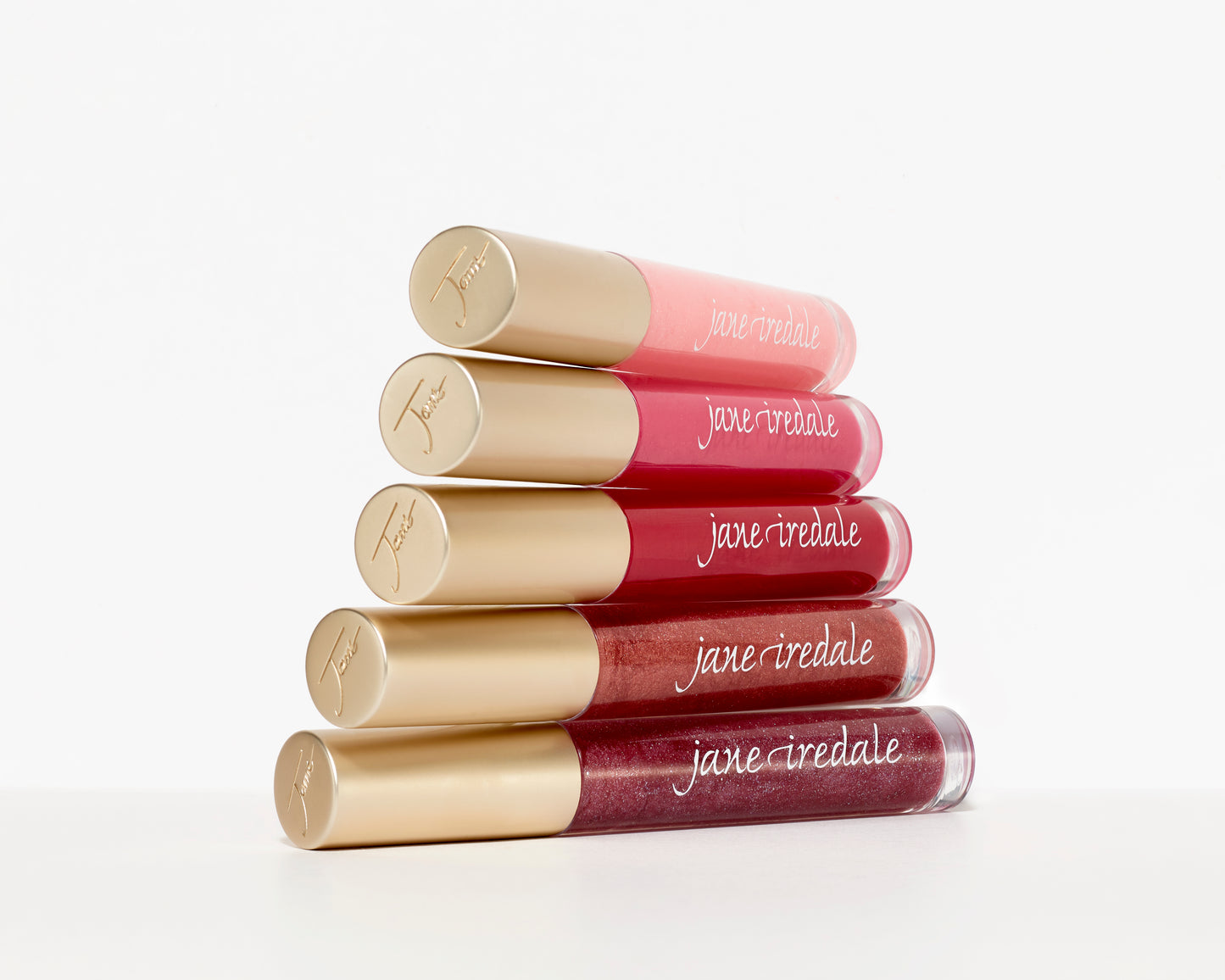 Five tubes of HydroPure™ Hyaluronic Acid Lip Gloss in pink and red shades, stacked in a pyramid, featuring gold caps and promising hydration and plumping effects.