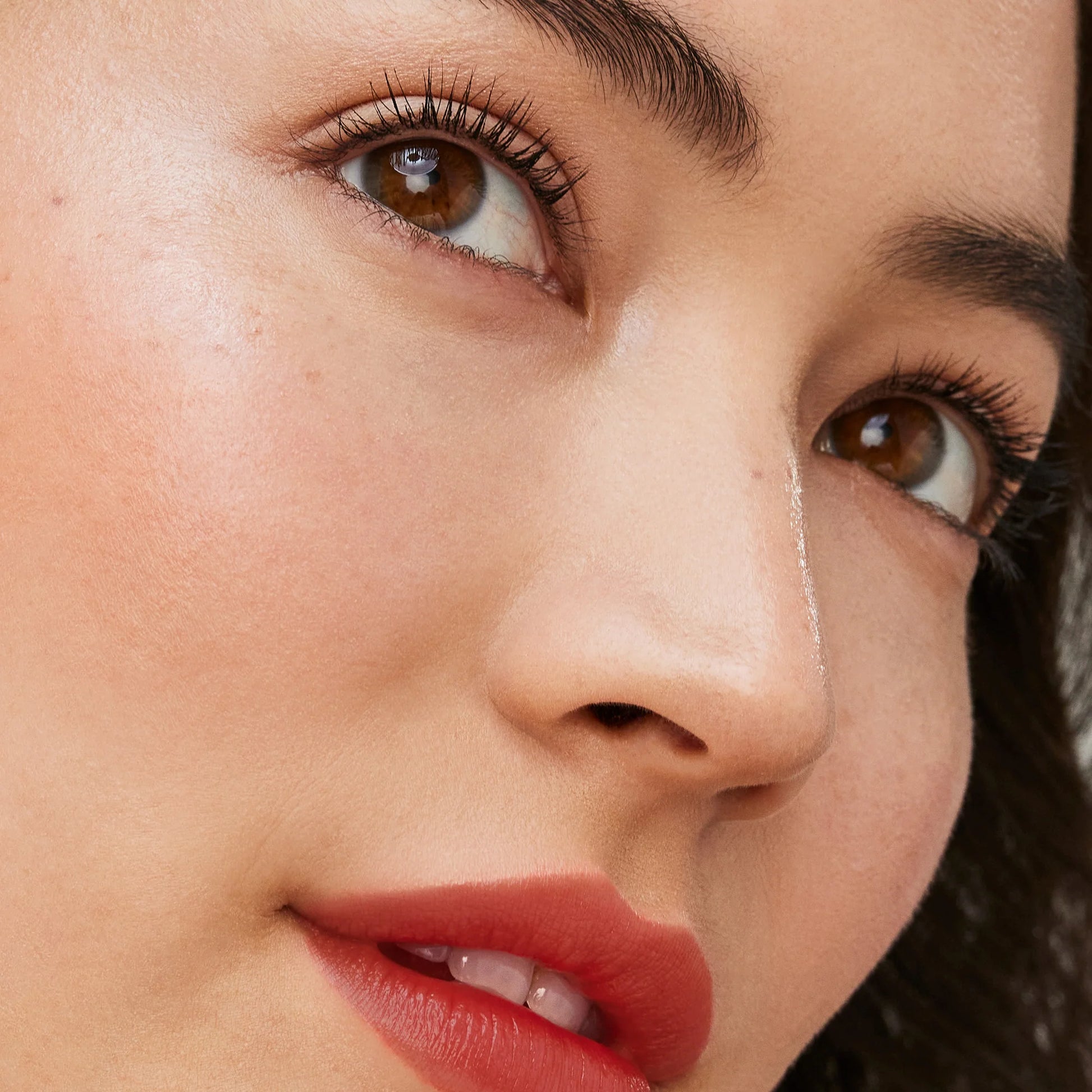 Close-up of eyes with Longest Lash Thickening and Lengthening Mascara, highlighting dramatic lashes, smooth skin, and vibrant lips, capturing beauty and elegance.